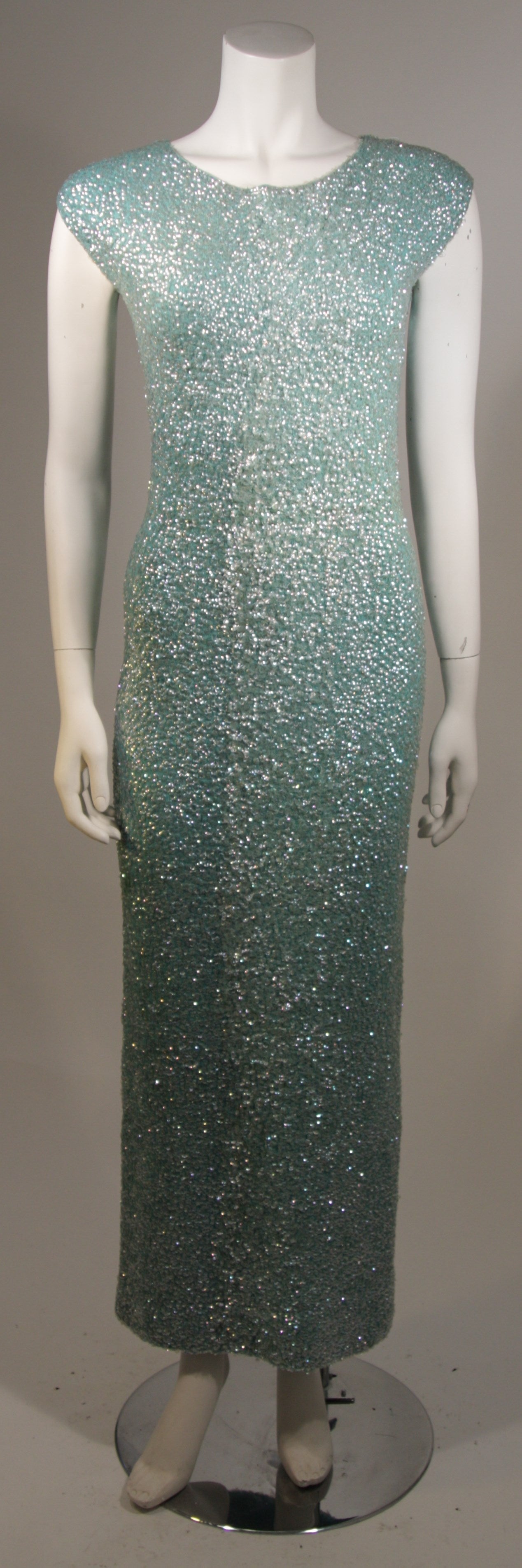 This fabulous gown is available for viewing at our Beverly Hills Boutique. The gown is composed of an aqua hued stretch knit adorned with iridescent sequins. There is a center back zipper for ease of access. A great color for spring and