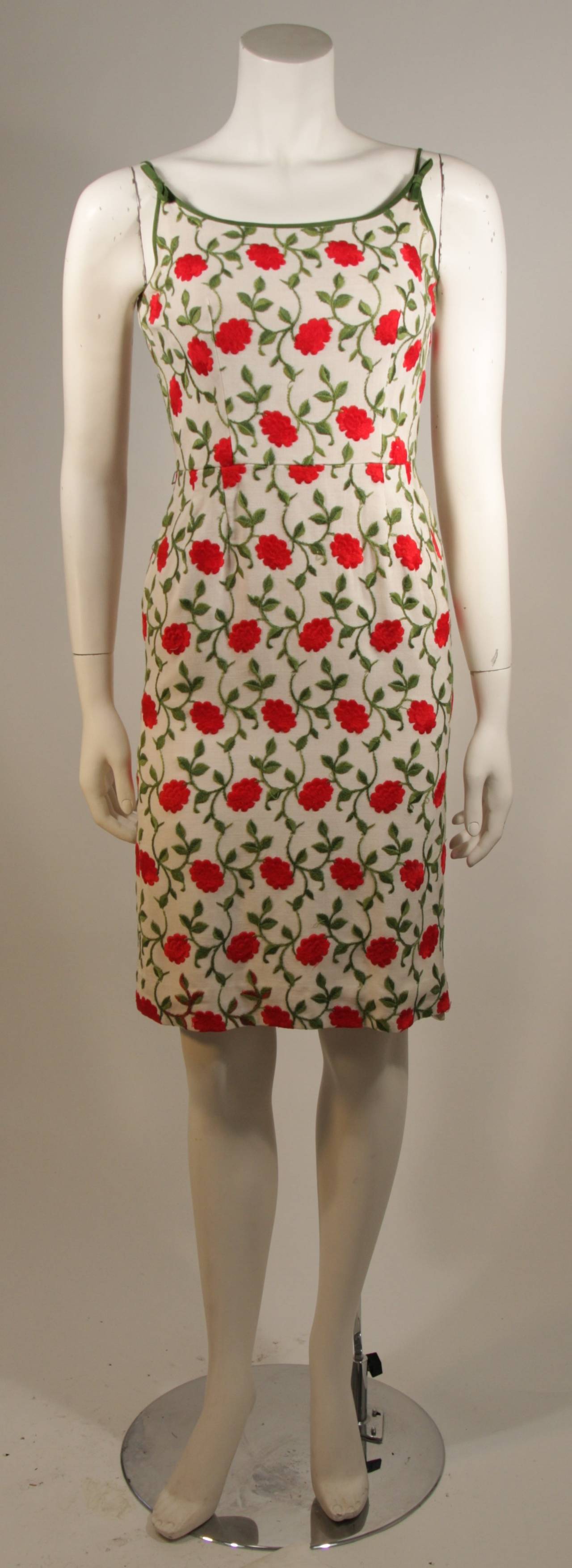 This embroidered cocktail dress is composed of a linen with red flower embroidery. There is a center back zipper for ease of access. The interior seam allowance is experiencing fraying, it is fixable. The dress is absolutely wonderful and features a