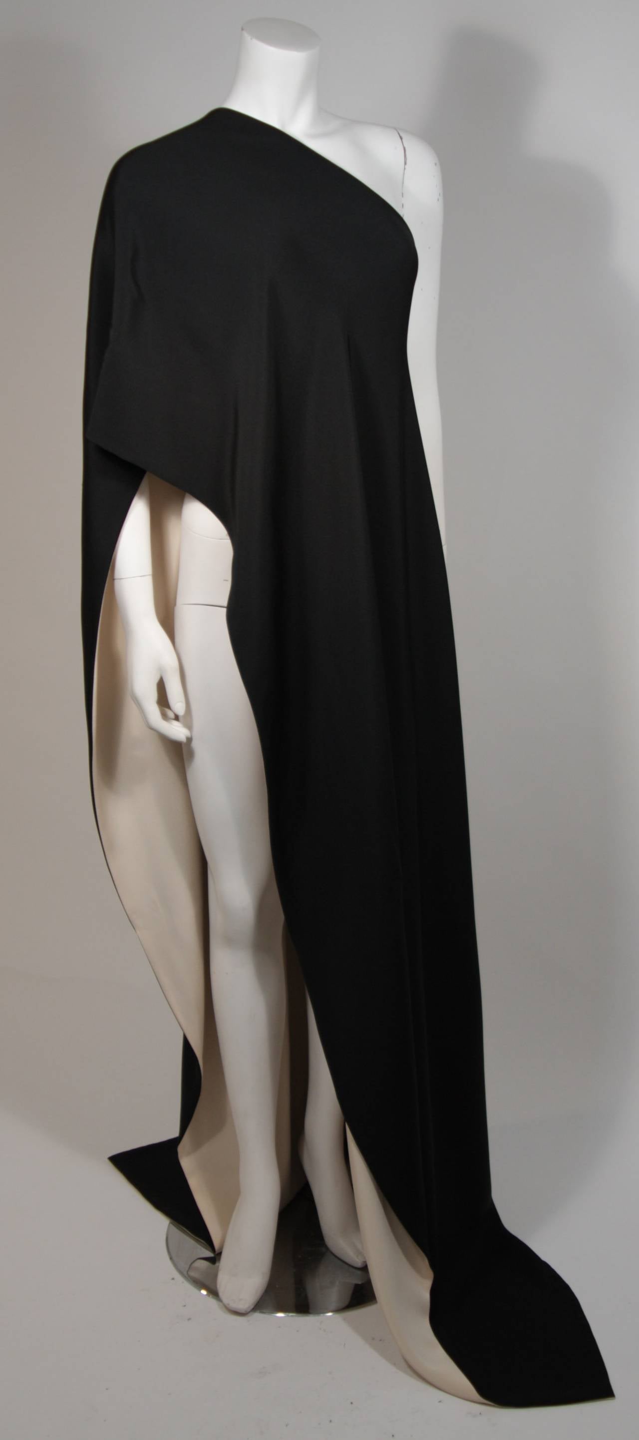 This Chanel design is available for viewing at our Beverly Hills Boutique. The drape style top is composed of a black silk and is lined with a cream silk. This piece is effortlessly chic and was made to be worn with the two black gowns we have