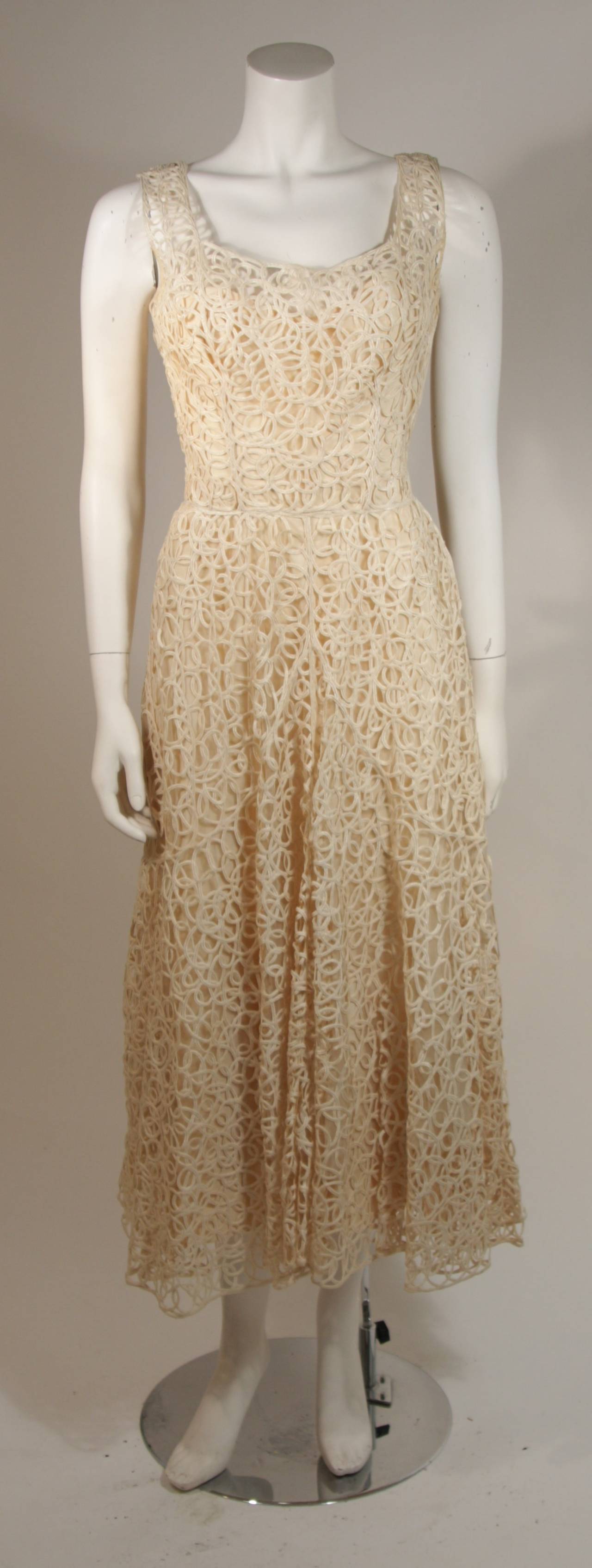 This Ceil Chapman cocktail dress is composed of a fabulous cream lattice work lace. There is a side zipper for ease of access. There is slight discoloration, but otherwise the dress is in Excellent Vintage Condition.  

Measures