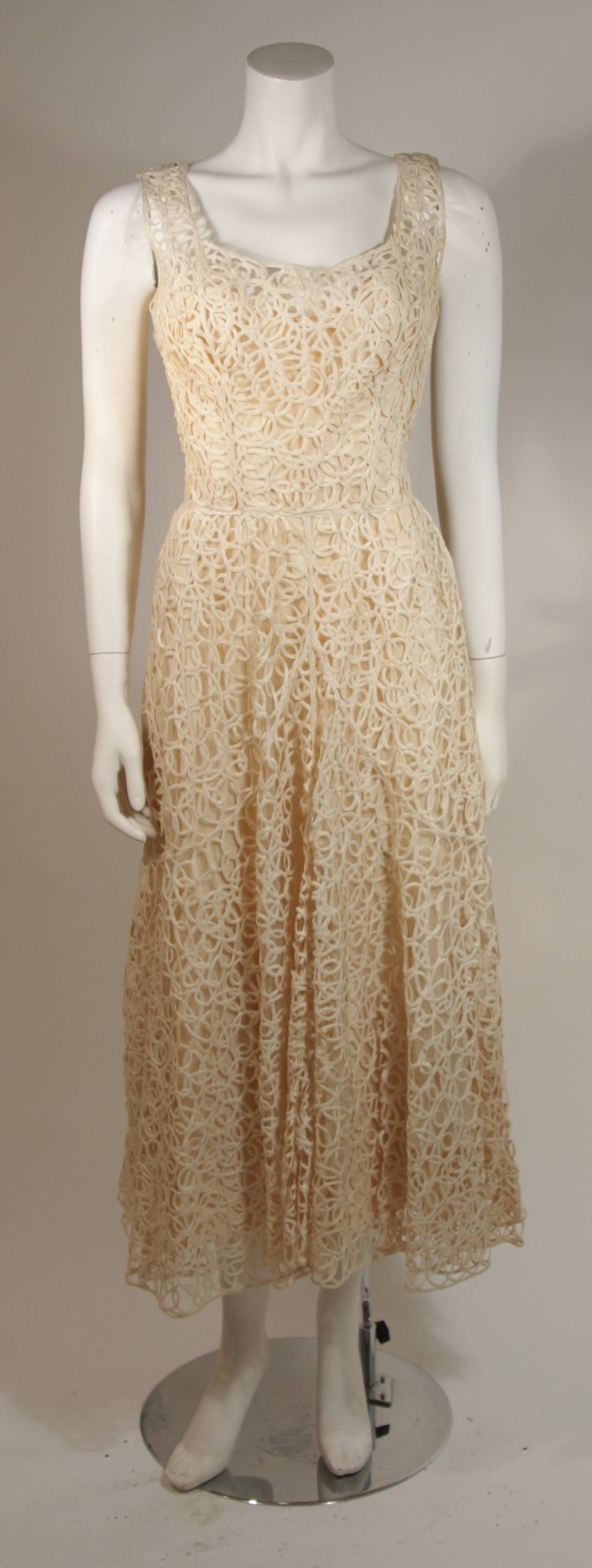 This Ceil Chapman cocktail dress is composed of a fabulous cream lattice work lace. There is a side zipper for ease of access. There is slight discoloration, but otherwise the dress is in Excellent Vintage Condition.  

Measures