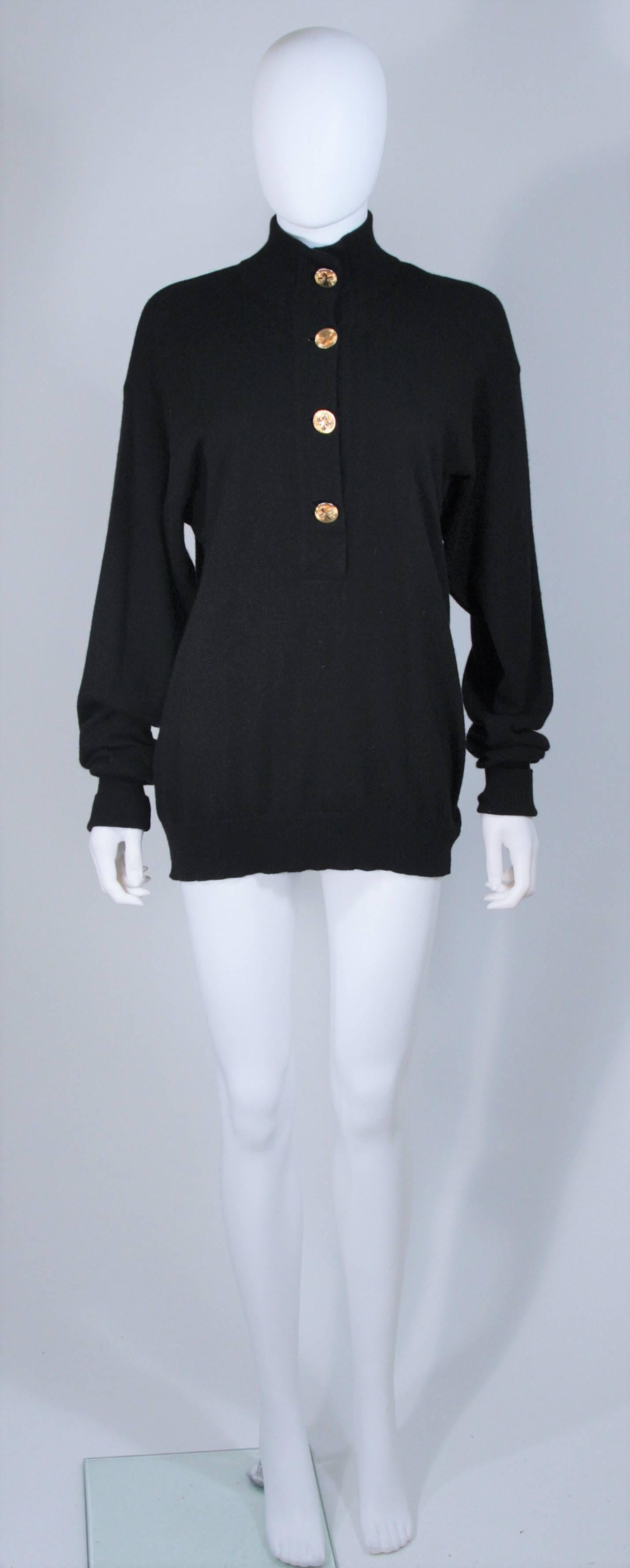  This Chanel sweater is composed of a black cashmere and features gold center front buttons. There is a mock neck style and fold over ribbed sleeves. In excellent vintage condition. 

**Please cross-reference measurements for personal