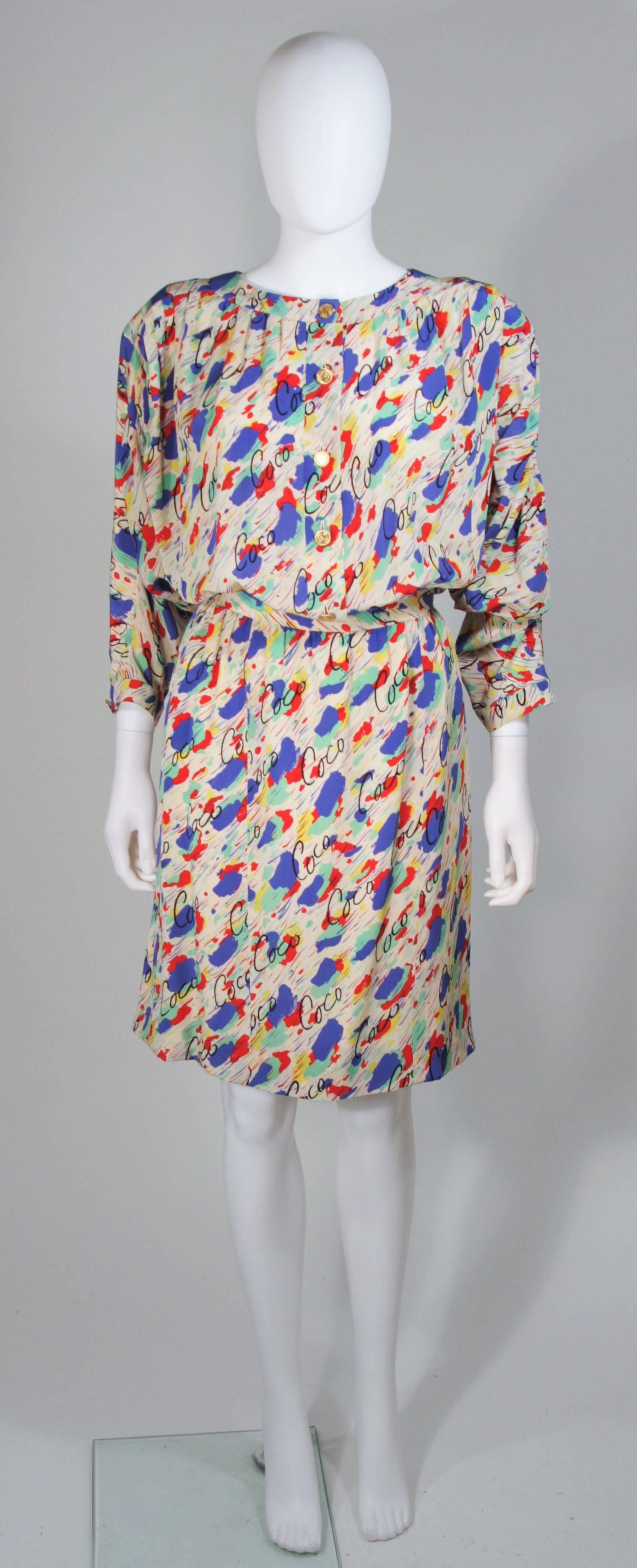  This Chanel set is composed of a silk with an abstract design and 'COCO' print. The blouse features a gathered style and 3/4 (padded removable at buyers discretion) dolman style sleeves, with center front button closures. The pencil style skirt