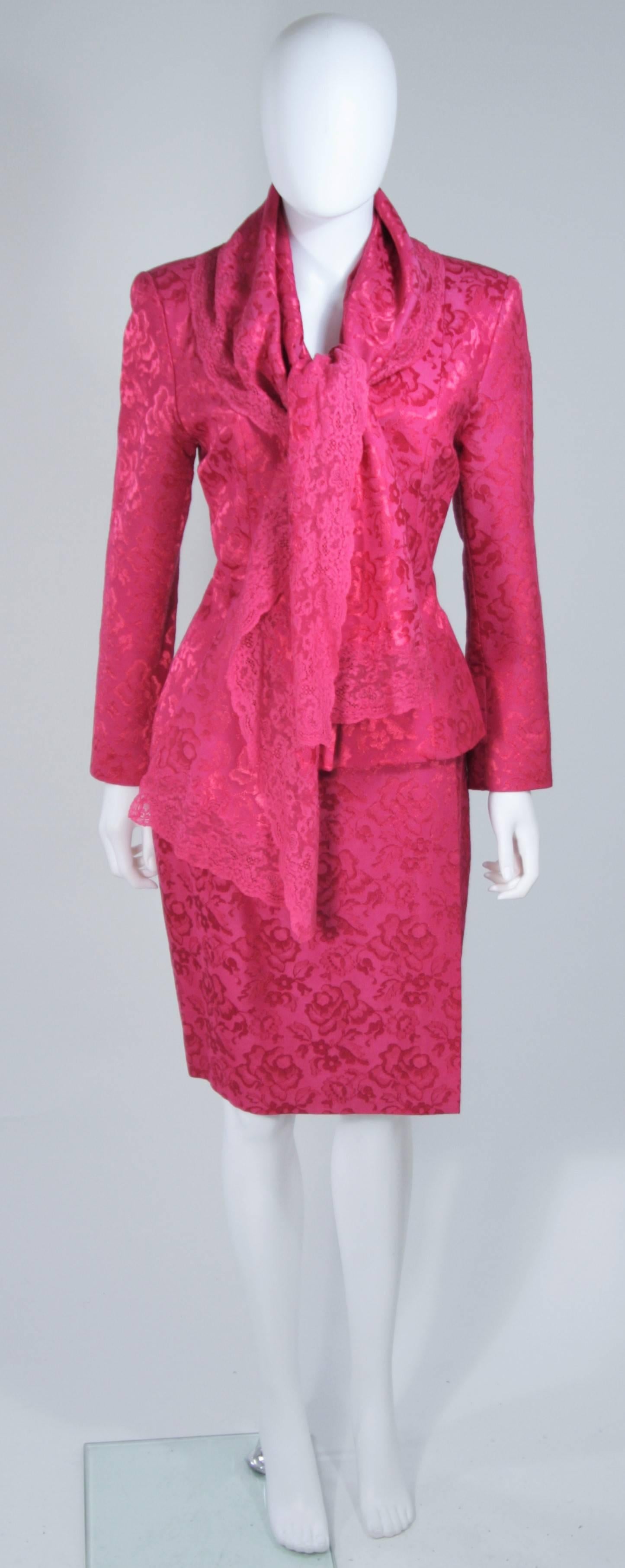  This Christian Dior ensemble is composed of a pink wool blend with floral patterning, lace trim, and silk lining. The jacket features a shawl style collar ad center front button closures. There is a wrap style skirt with button closures and classic