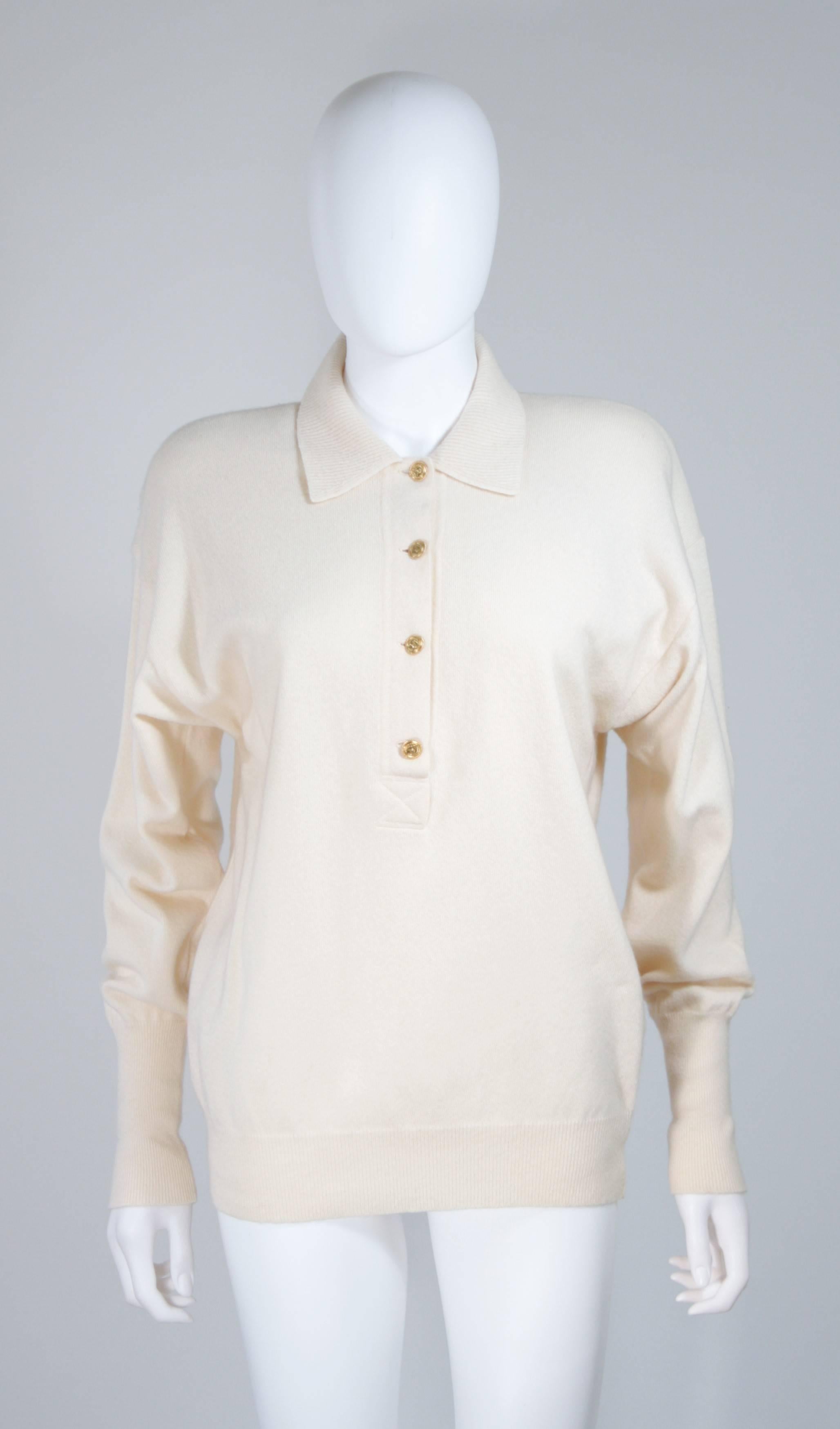  This Chanel sweater is composed of a cream cashmere and features gold center front buttons. There ae shoulder pads which maybe easily removed at the buyers discretion. In excellent vintage condition. 

**Please cross-reference measurements for
