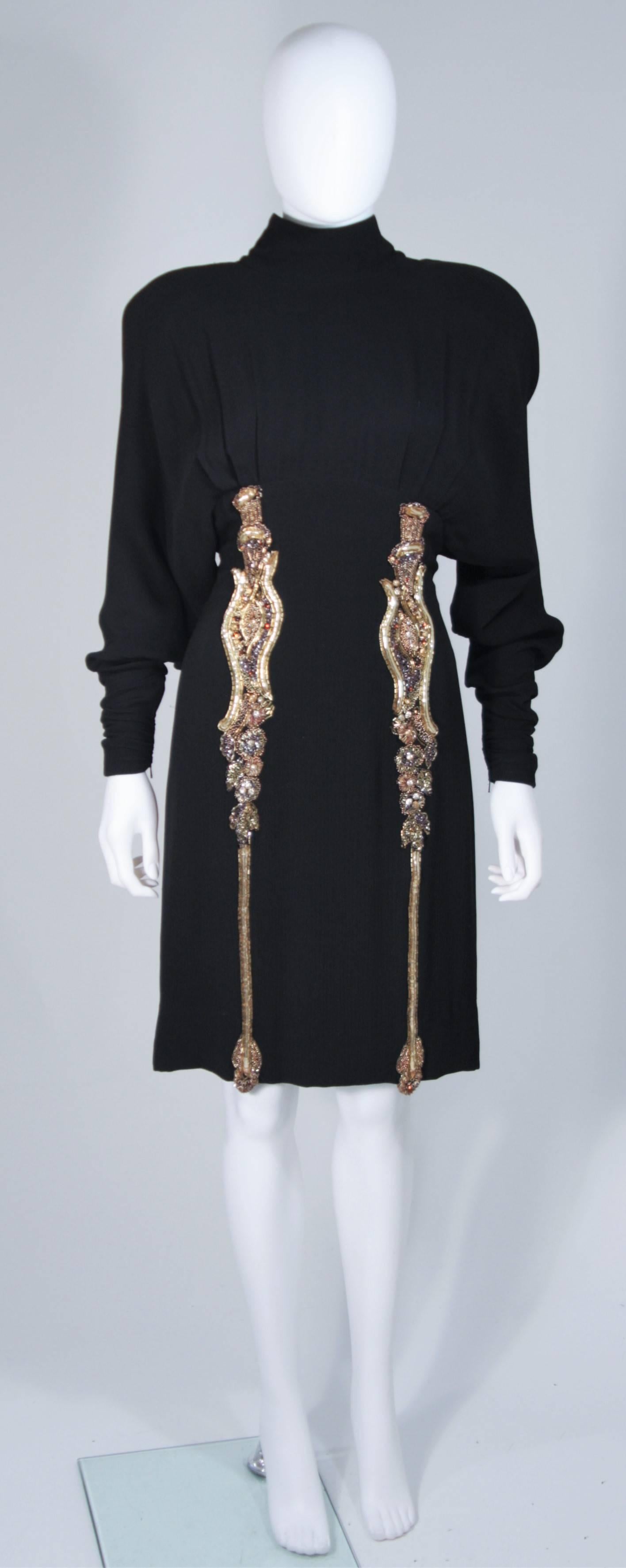 This Karl Lagerfeld cocktail dress is composed of an embellished black silk. Features two large beaded appliques on the front, dolman style sleeves, a center back zipper, and rouched sleeve ends with zippers. In excellent vintage condition.