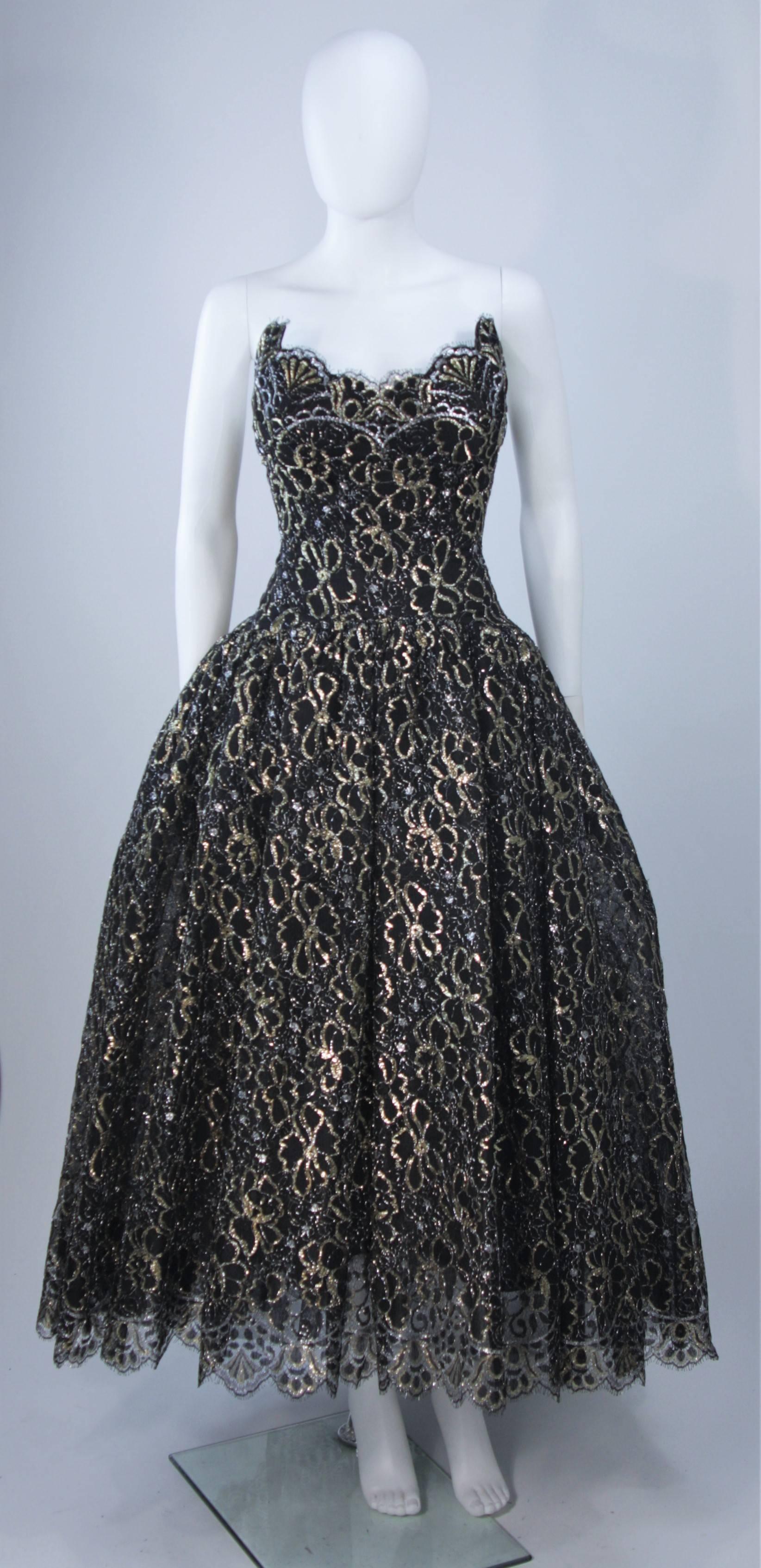  This Scaasi gown is composed of a black and gold floral patterned lace. The gown bodice features an exaggerated scalloped edge and the full skirt is layered for volume (also shot with additional crinoline). There is a center back zipper and boned