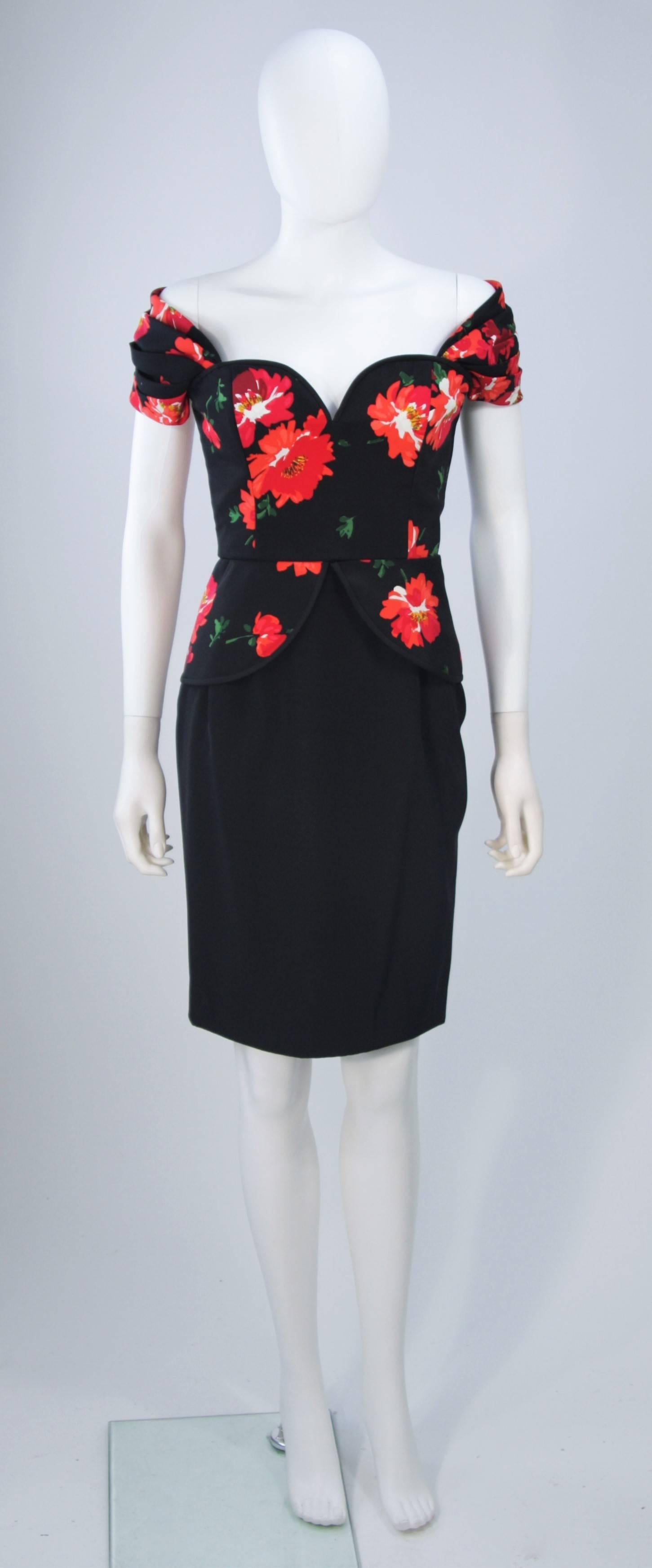  This Andrea Odicini  cocktail dress is composed of a black floral print silk with a bias cut edge (piping). The off the shoulder style design is accented by a structured peplum detail at the waist. Feature a structured neckline with a side zipper