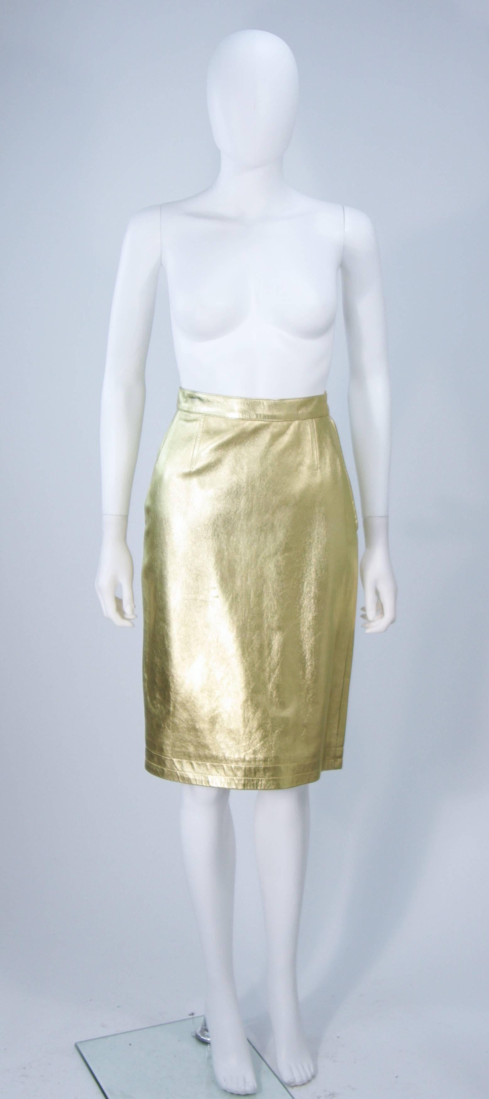  This Yves Saint Laurent skirt is composed of a gold metallic leather. Features a side zipper and top stitched darts. In excellent vintage condition.

This YSL gold leather skirt is from an extensive collection I acquired from the estate of a very
