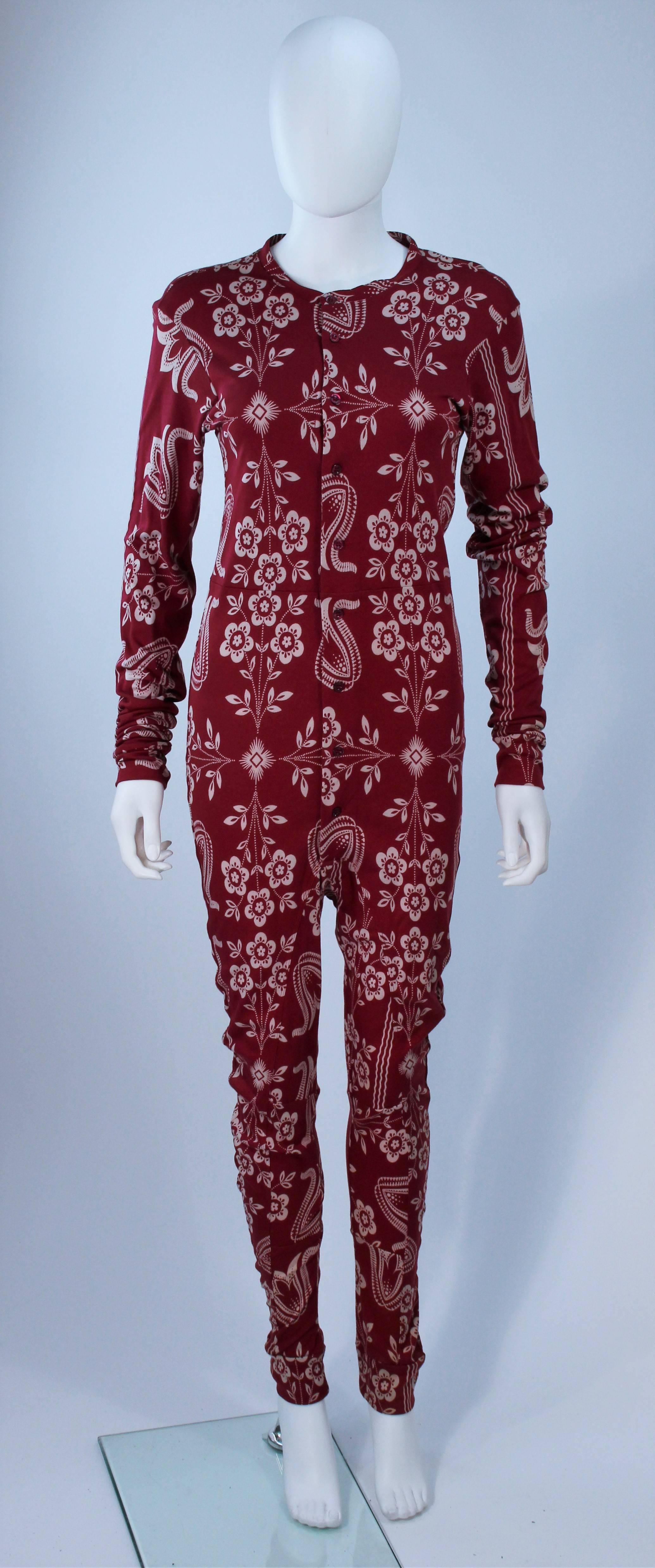This John Galliano onesie is composed of a burgundy printed knit. There are center front button closures. In excellent condition, has original tag, possibly never worn. 

Measures (Approximately)
Length: 60