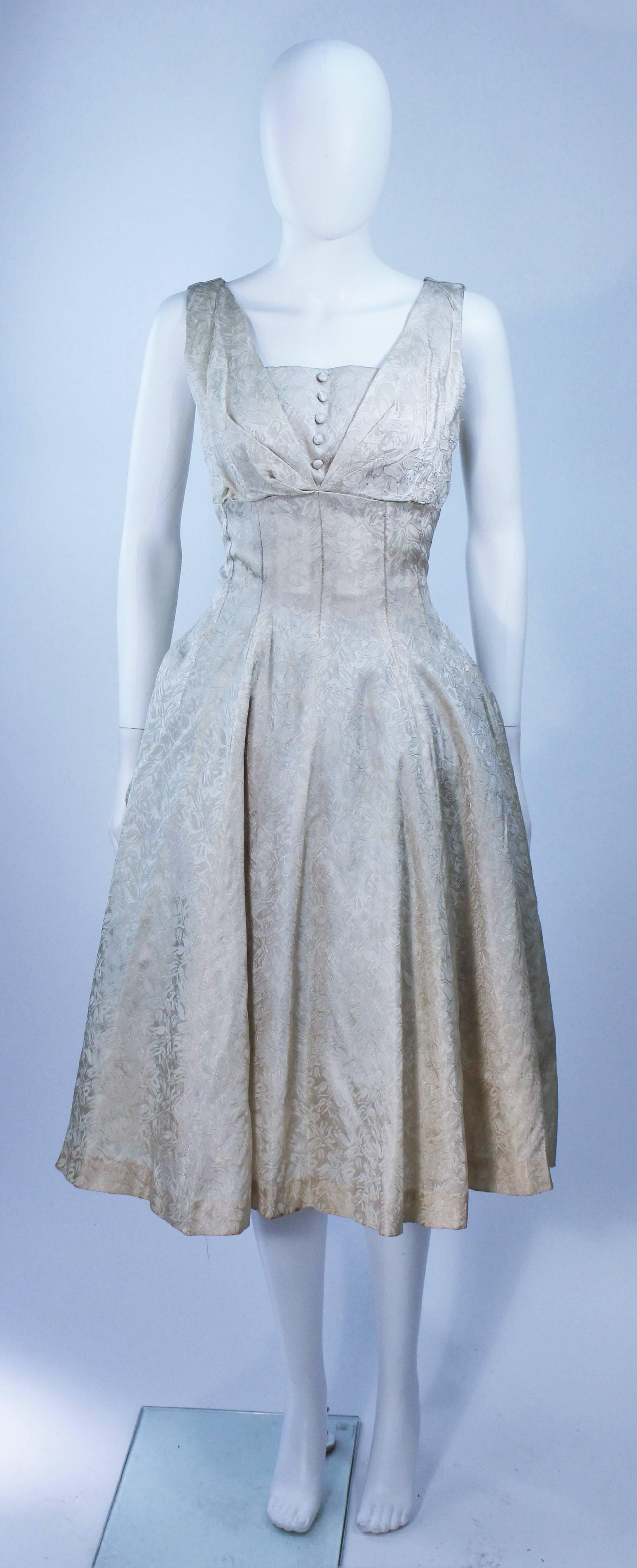  This dress is composed of an off white cream brocade. Features center front button accents and a zipper closure. In great vintage condition. 

  **Please cross-reference measurements for personal accuracy. 

Measures (Approximately)
Length: