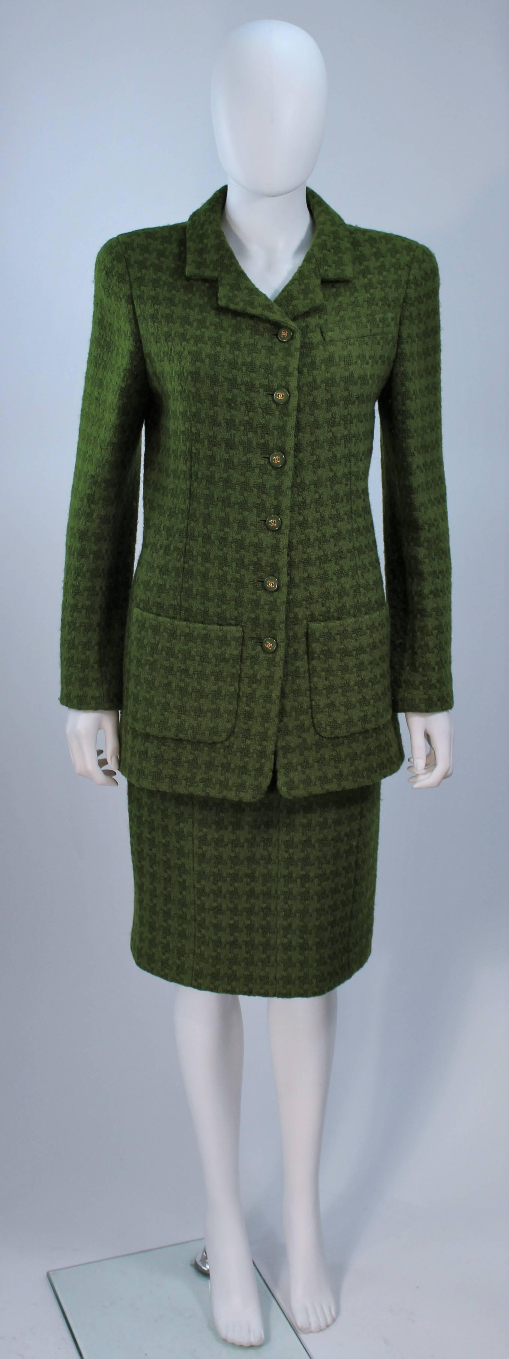  This Chanel  suit is composed of a green wool with a houndstooth pattern and silk lining. The coat features center front button closures, and the classic pencil style skirt features a zipper closure with hook and eye. In excellent vintage