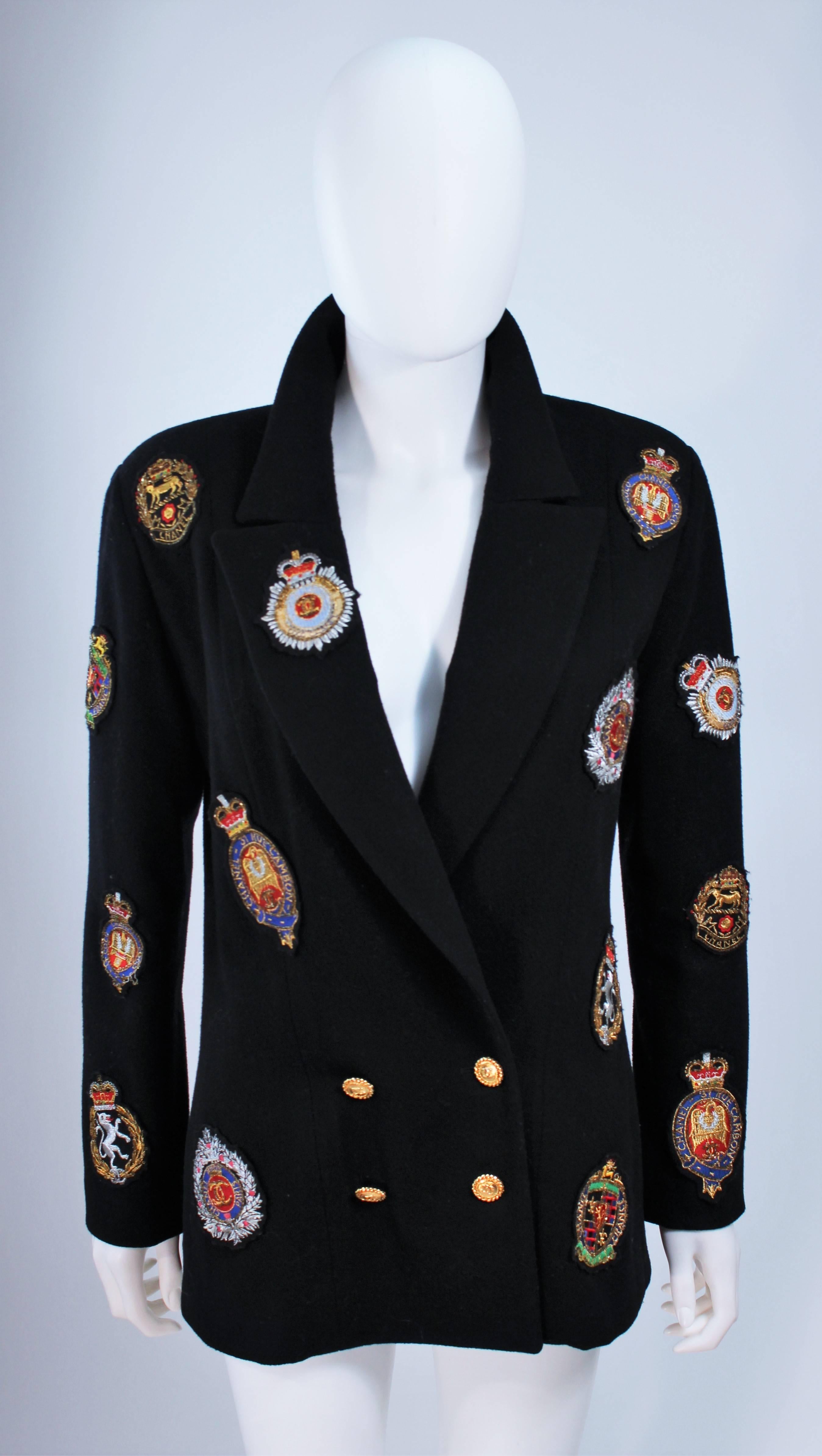  This Chanel Boutique design is available for viewing at our Beverly Hills Boutique. We offer a large selection of evening gowns and luxury garments. 

 This coat is composed of a soft black cashmere with coat of arms patch applique. The patches