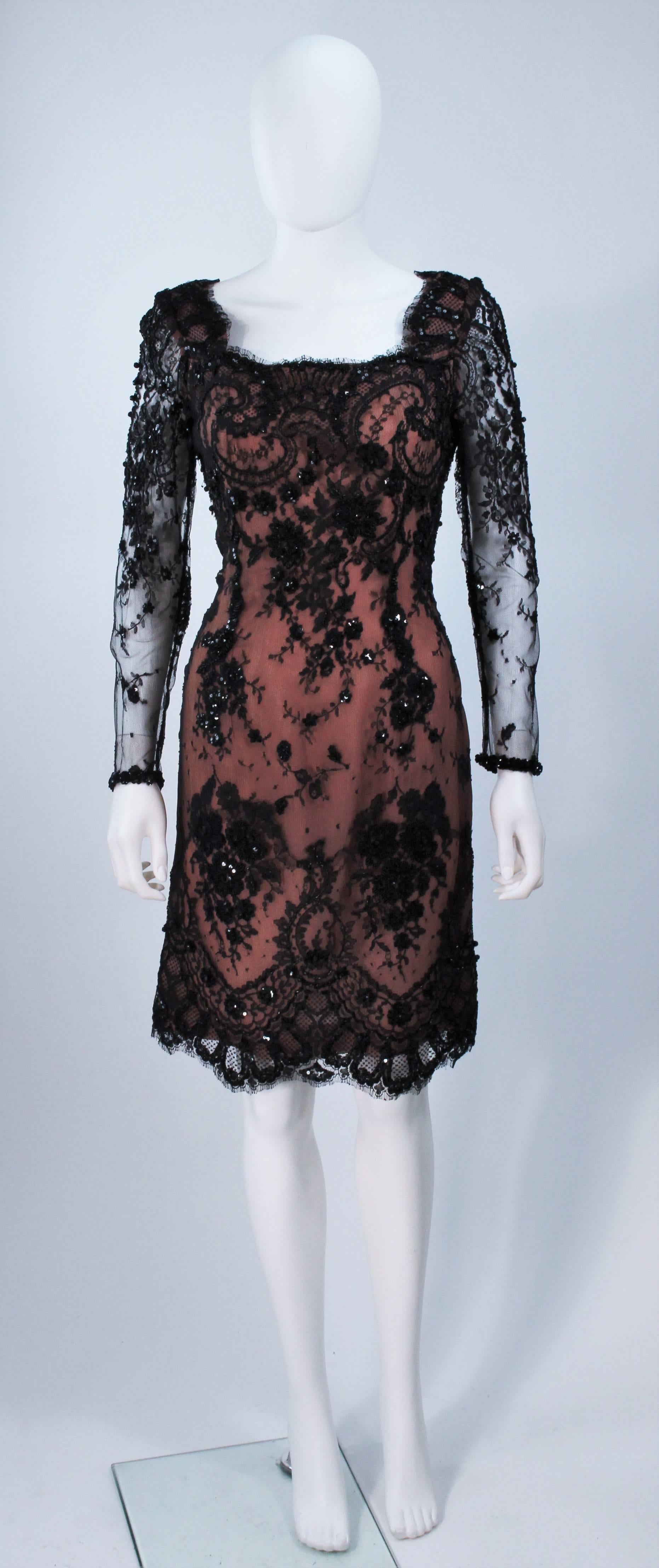  This Fe Zandi  cocktail dress is composed of black lace with a nude tone silk base. The lace features beaded applique with sequins and a scalloped edge. There are sheer sleeve, with a center back zipper closure. In excellent vintage condition. 

