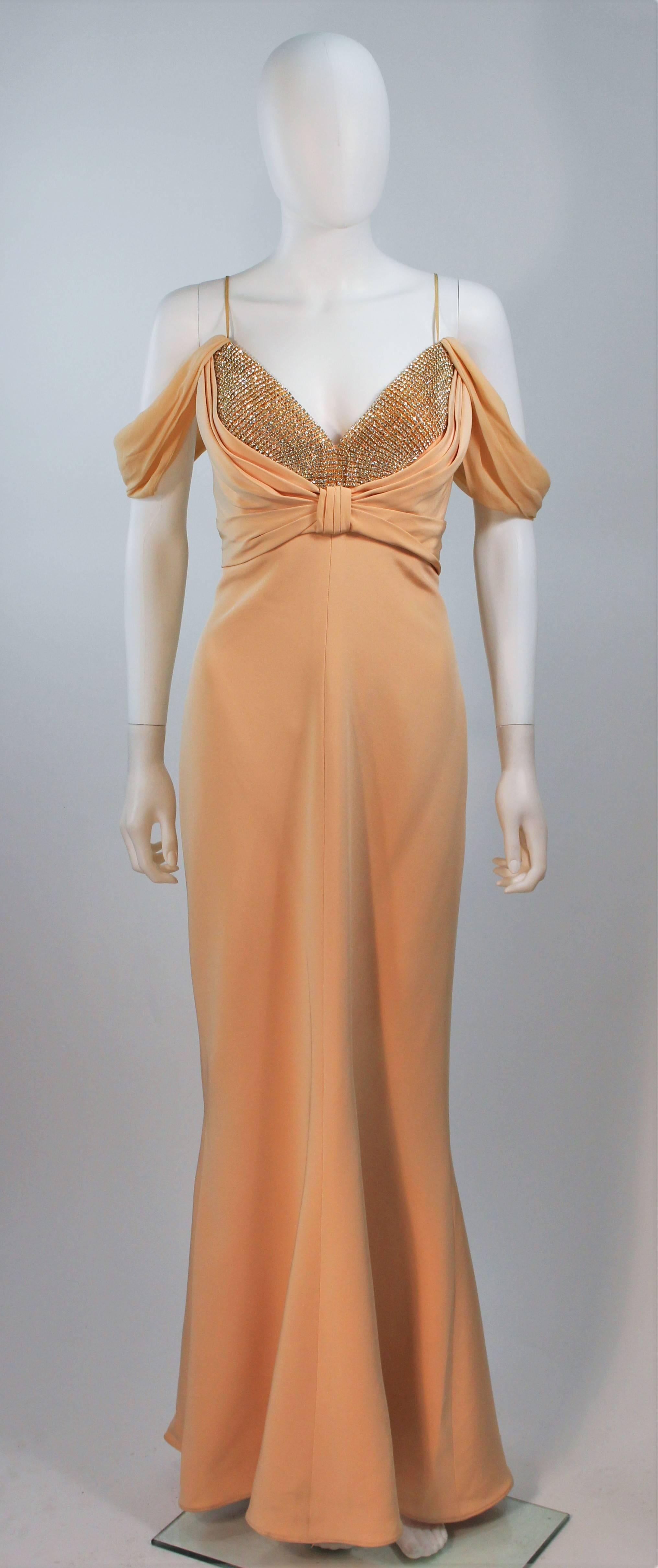  This Sam Carlin  gown is composed of a nude silk fabric with embellished bust and chiffon draped sleeve detail. This garment is boned, features a center back zipper. This stunning gown is in excellent vintage condition with original tags. 

 