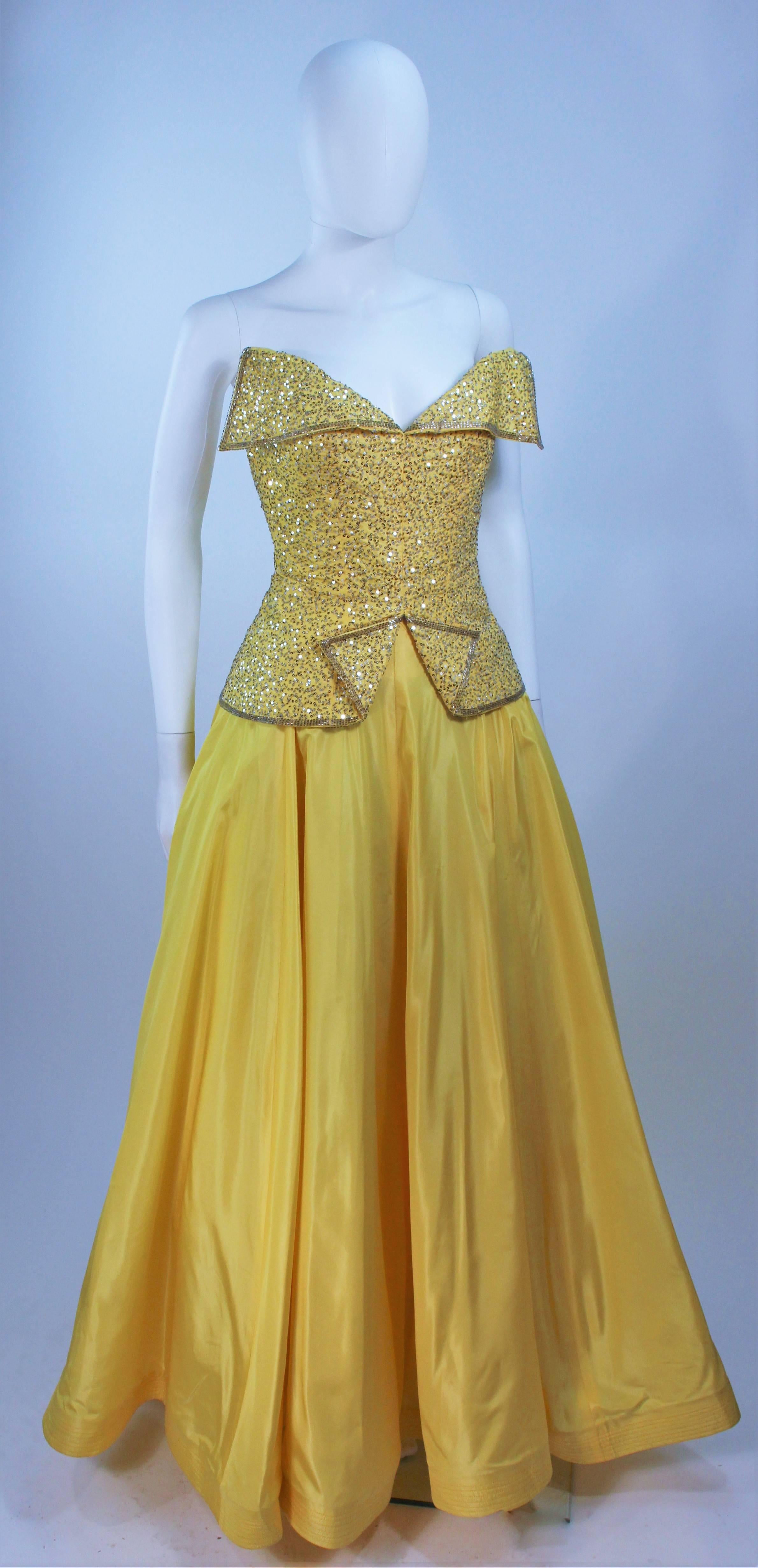  This Murray Arbeid  gown is composed of a yellow silk and features silver sequin applique. The structured bodice features an exaggerated bust and interior bustier foundation with boning. There is interior crinoline (was shot with additional