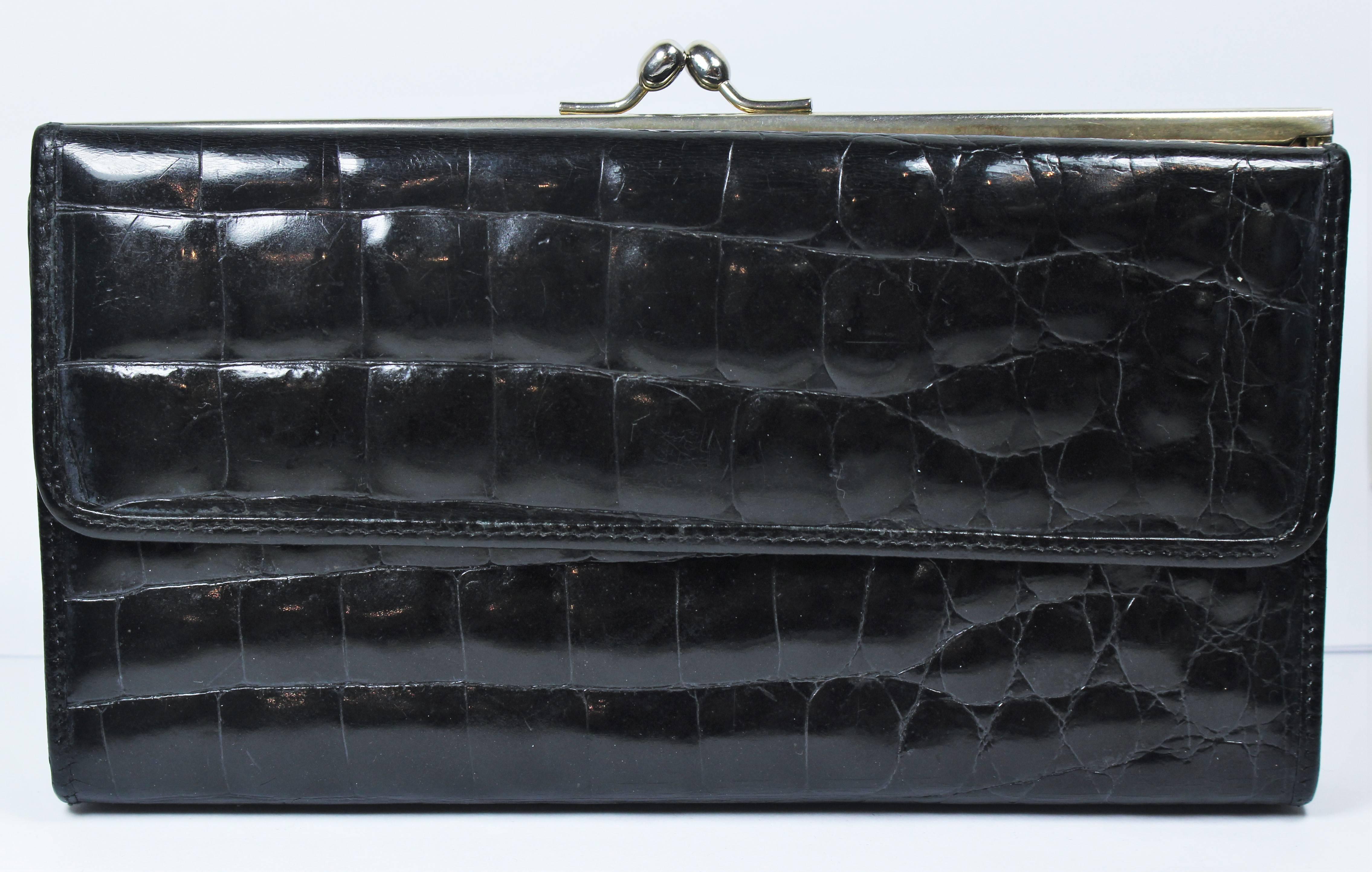 This vintage Neiman Marcus  wallet is composed of a black crocodile with silver tone frame. Features a snap closure clasp. In excellent vintage condition.

**Please cross-reference measurements for personal accuracy.

Measures