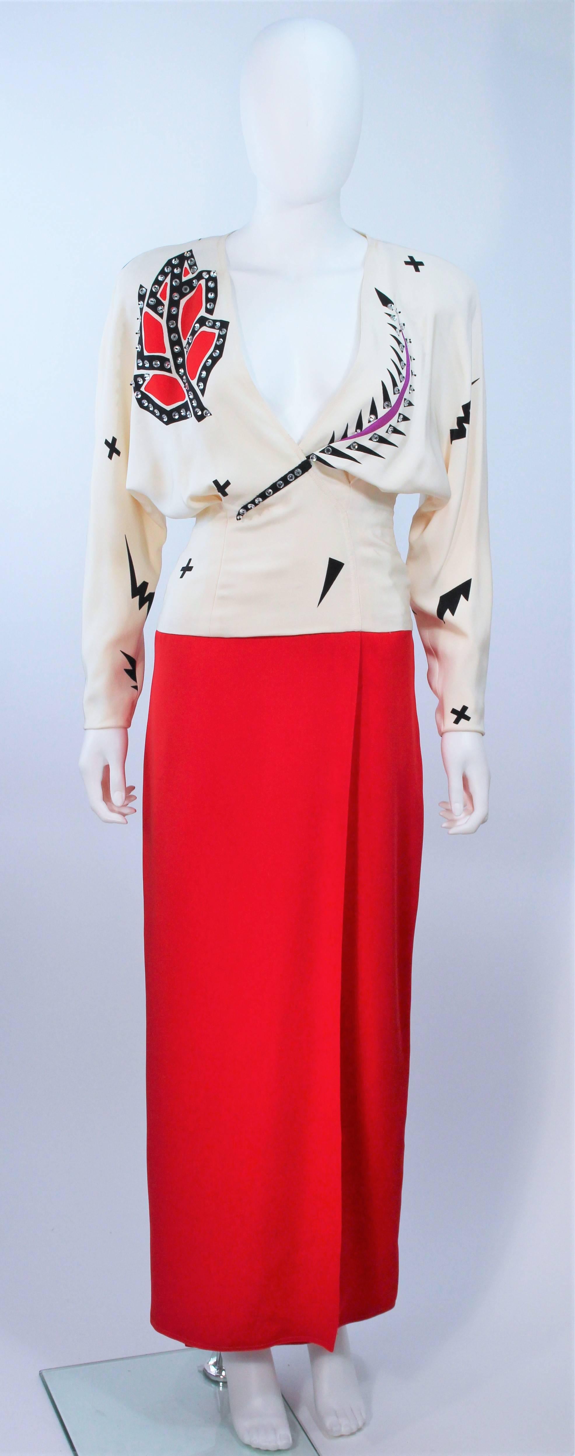  Cette robe de Fabrice est composée d'une soie écrue et rouge. Comprend une jupe pleine longueur avec fente et des manches de style drapé. Il y a une fermeture à glissière latérale et une application de strass. Vintage, en excellent état. 

 