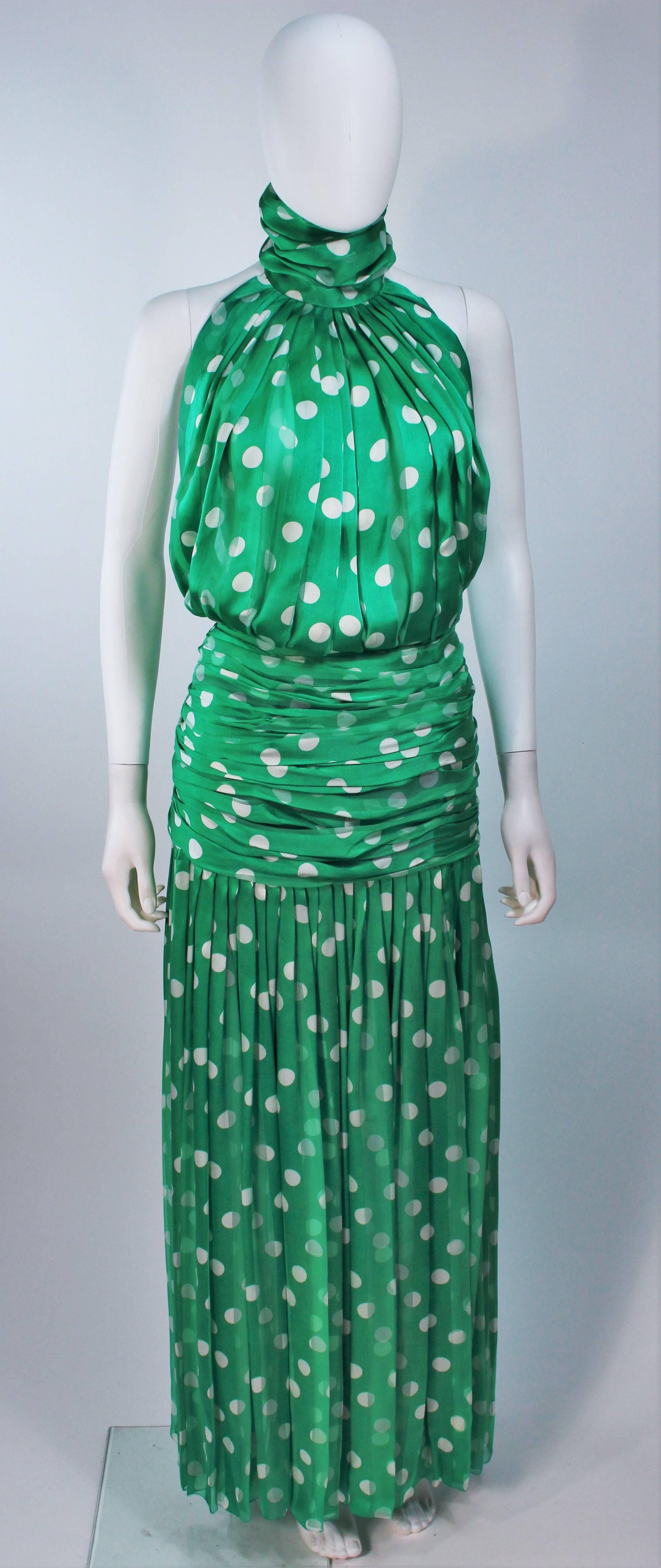  This Jiki  gown is composed of green and white polka dot silk. Features a halter mock neck with an open back, and a ruched waist to hip. There is a center back zipper. In excellent vintage condition. 

  **Please cross-reference measurements for