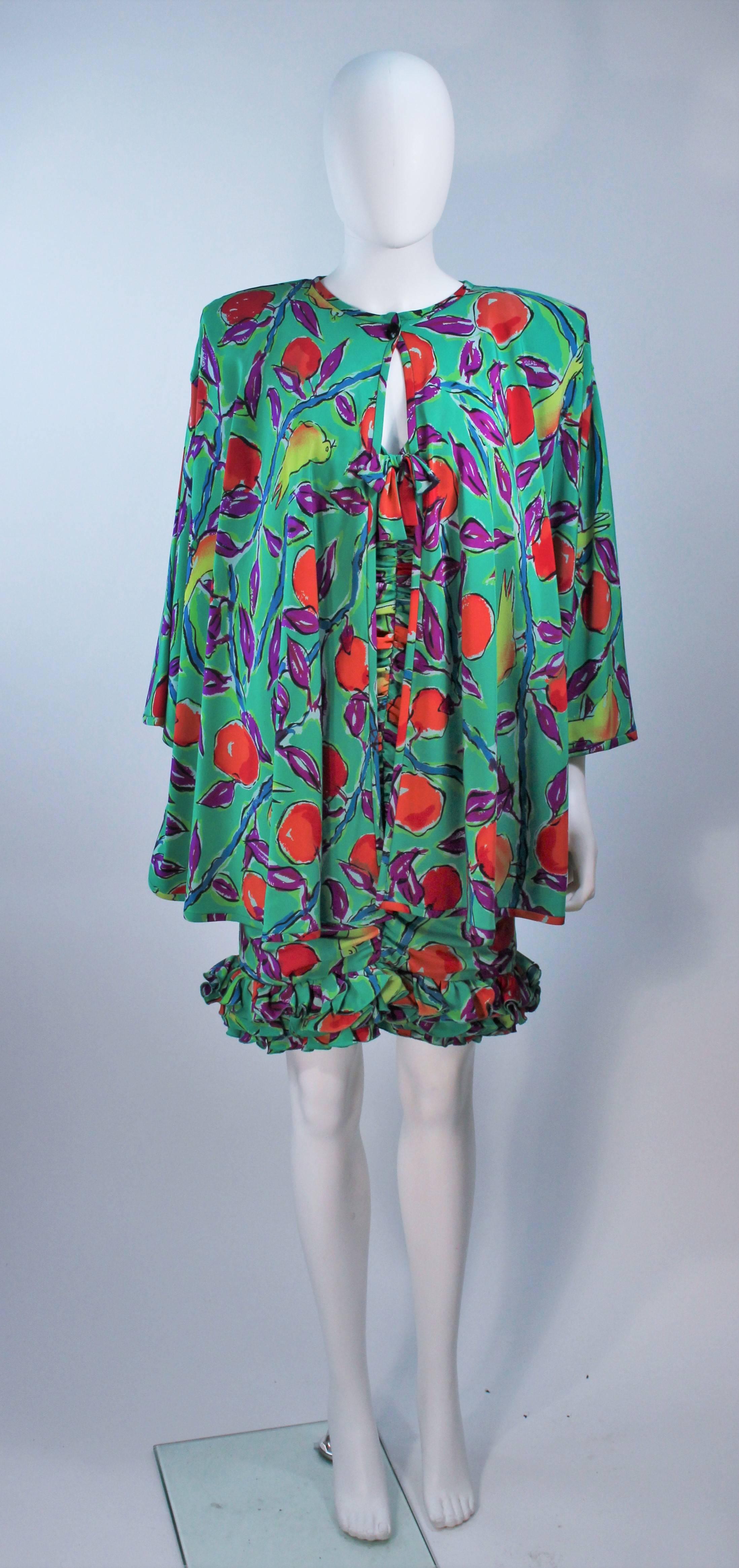  This Emanuel Ungaro set is composed of a printed teal silk with a floral and bird motif. The cocktail dress features a center front box and ruffled hem. The jacket has a hook and eye closure with a black faceted button closure. In excellent vintage