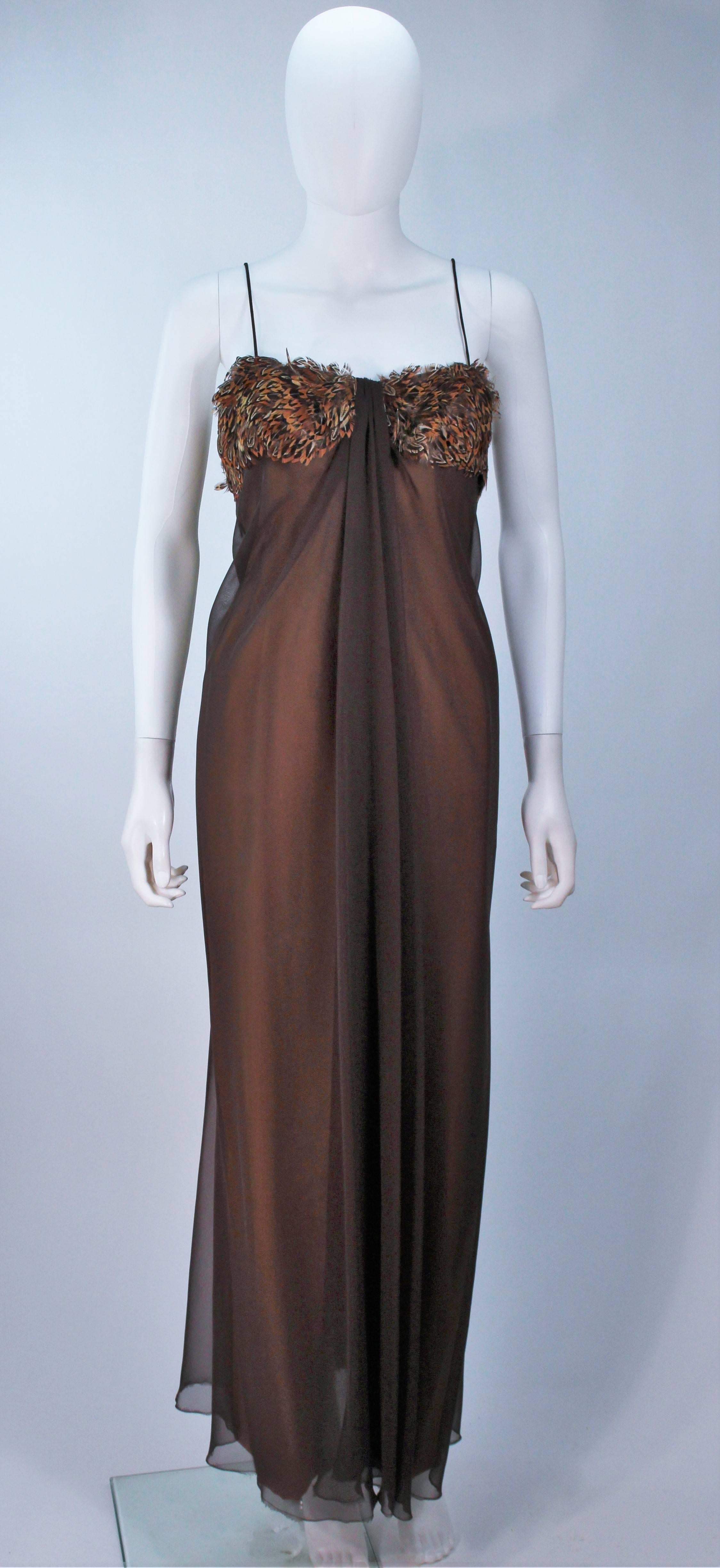  This Travilla gown is composed of a brown silk chiffon. Features a center front drape and peasant feather applique. There is a center back zipper closure. In excellent vintage condition.

  **Please cross-reference measurements for personal