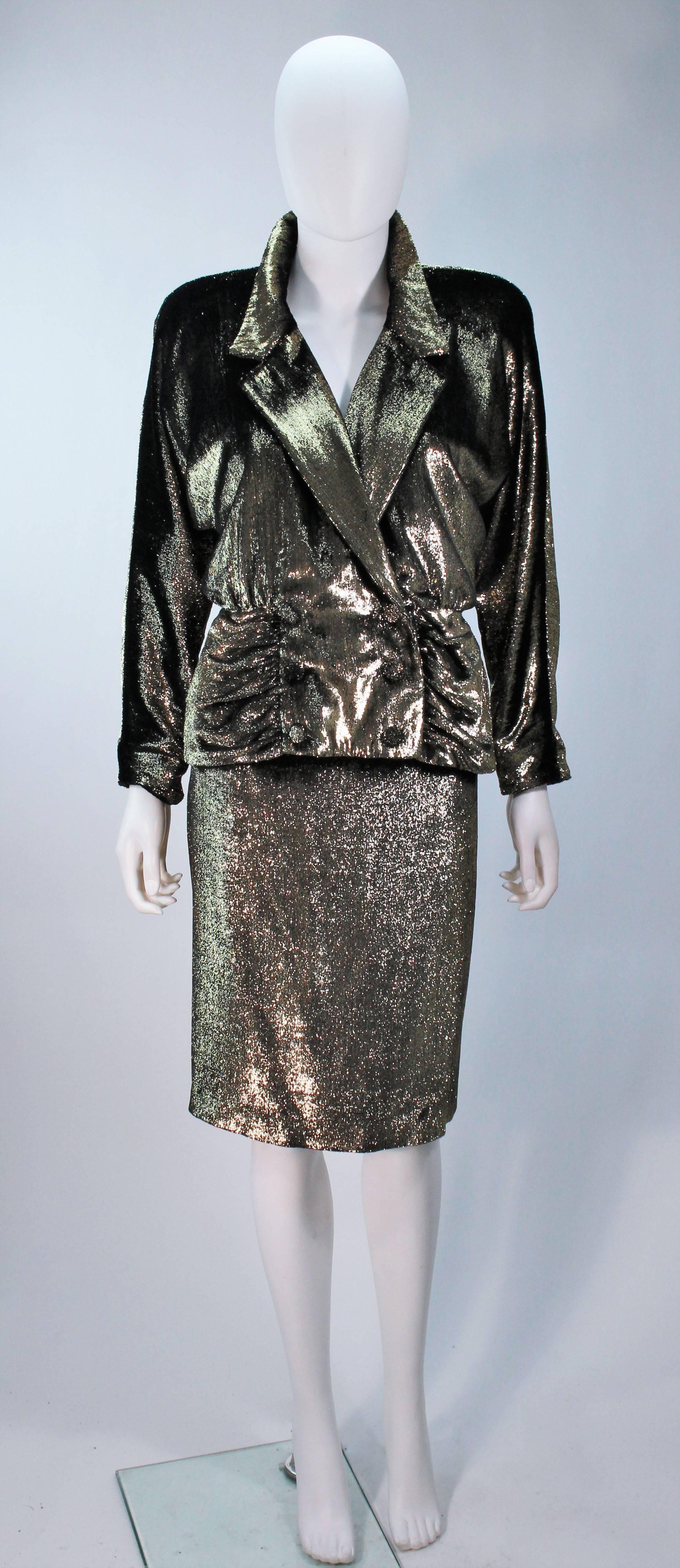  This Travilla  skirt suit is composed of a black and gold metallic velvet lame. The suit jacket features center front closures, shoulder pads, and a draped neckline. The skirt has a zipper closure. In excellent vintage condition.

  **Please