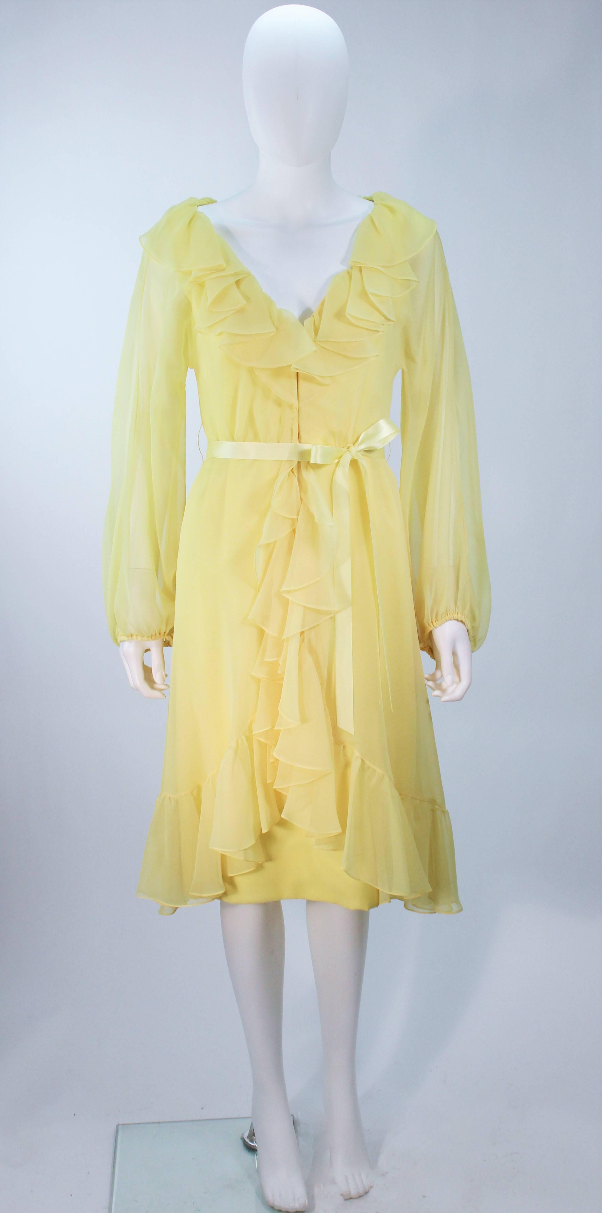  Dieses Kleid von Travilla besteht aus gelbem Chiffon. Mit gerüschtem Halsausschnitt und geblähten Ärmeln. Es gibt einen Reißverschluss mit Haken und Öse. In großen Vintage-Zustand, gibt es Verfärbungen (siehe Fotos). 

  **Bitte vergleichen Sie