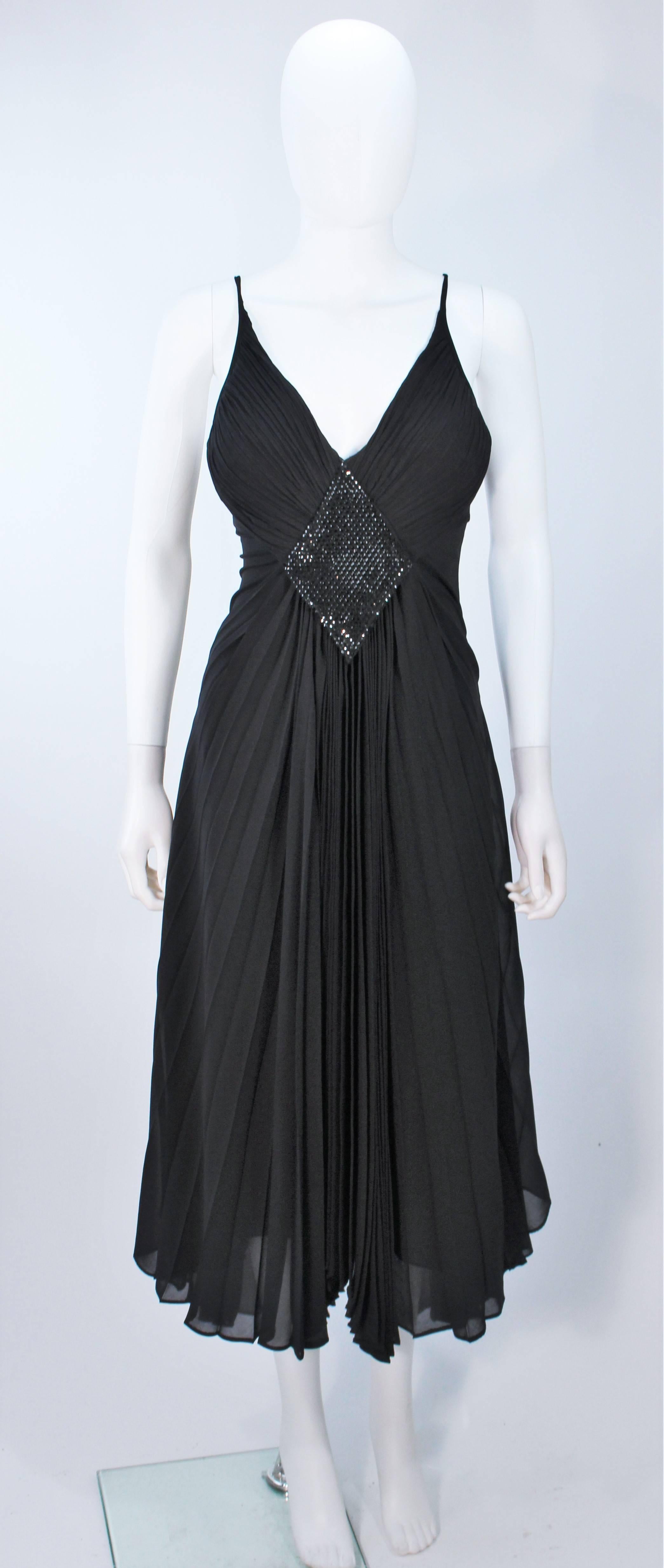  This Paco Rabanne dress is composed of a fine pleated silk jersey and features a center front rhinestone detail. There is a center back zipper closure, interior boning, and an attached bra. In excellent vintage condition. 

  **Please