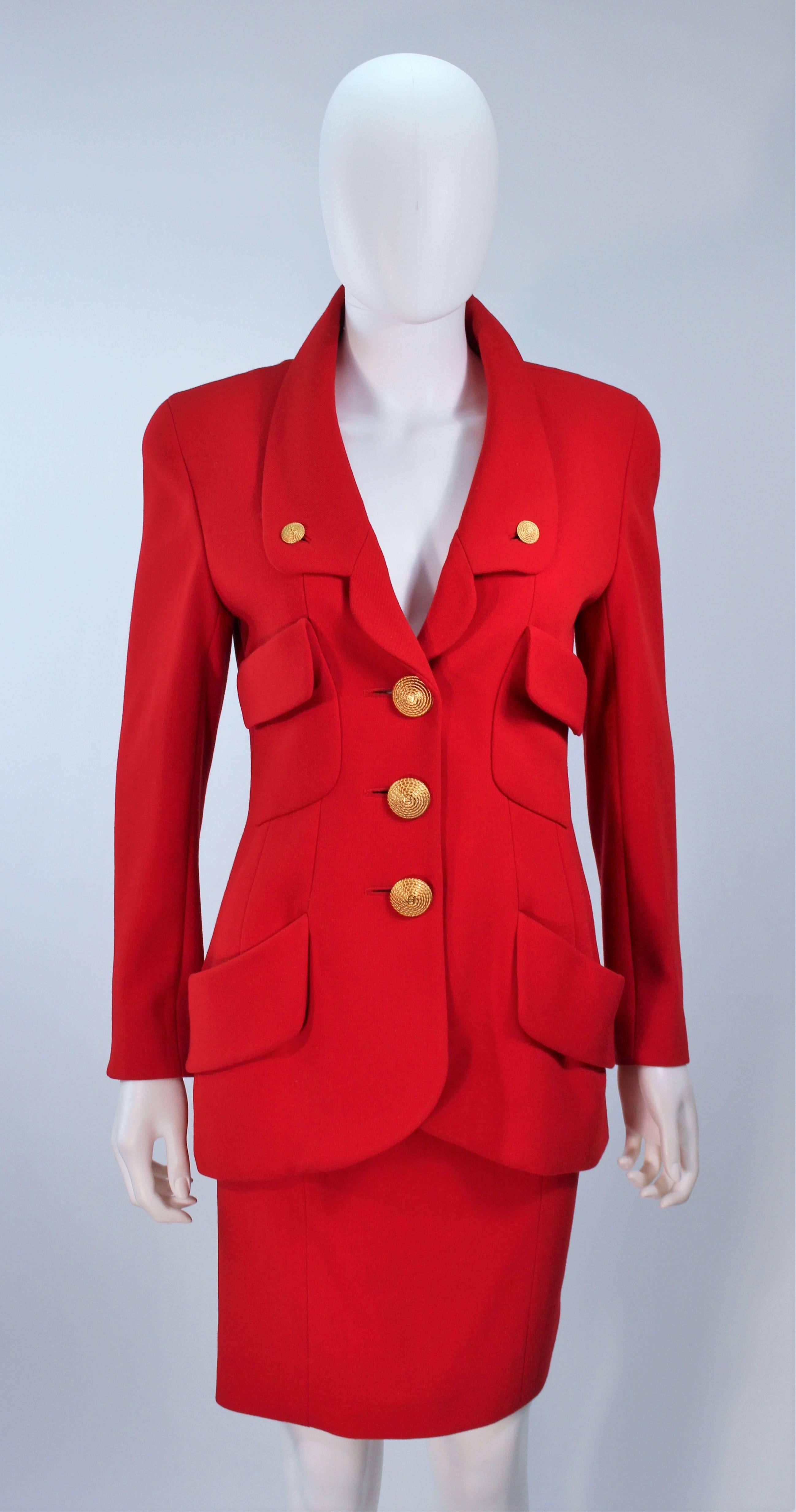  This Chanel skirt suit is composed of a red wool with braided-textured gold 'CC' logo  buttons as well as a silk lining. The jacket features center front button closures and a safari style. The classic pencil style skirt features a zipper closure.