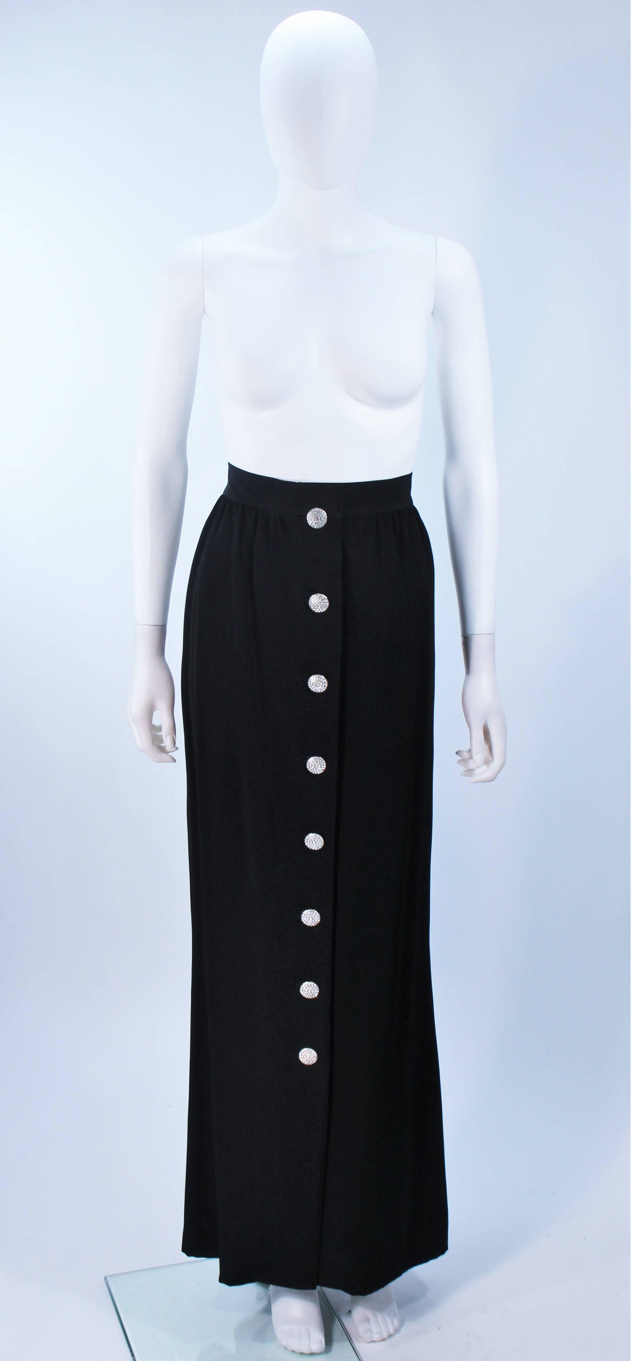  This Yves Saint Laurent skirt is composed of a black acetate blend. Features a center front rhinestone buttons, and side pockets. In excellent vintage condition, with original tags. 

This YSL evening skirt is from an extensive collection I