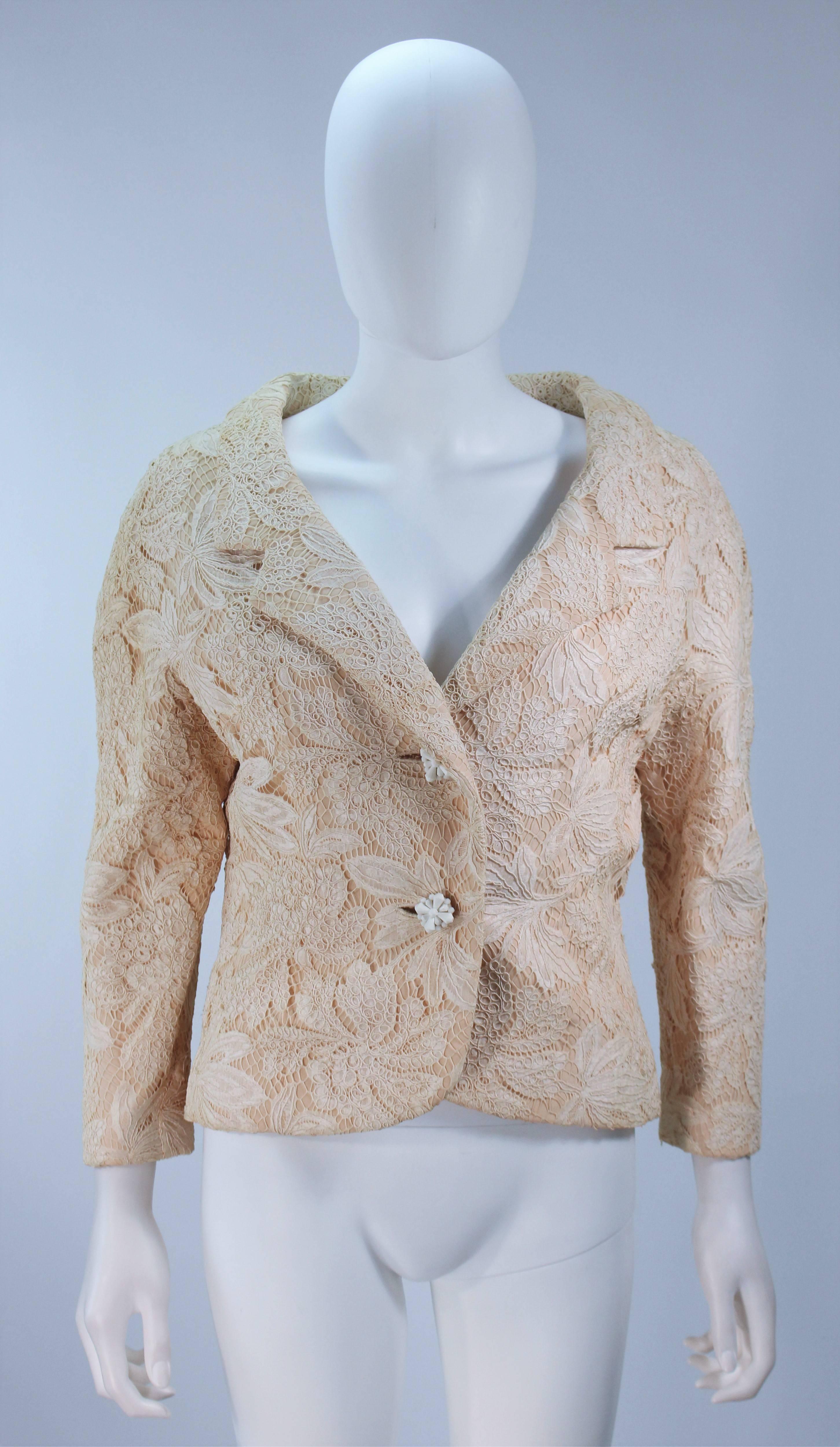  This Galanos jacket is composed of an off white cream hued floral lace. There are center front button closure with a wide neckline design. Silk lining. In excellent vintage condition. 

  **Please cross-reference measurements for personal