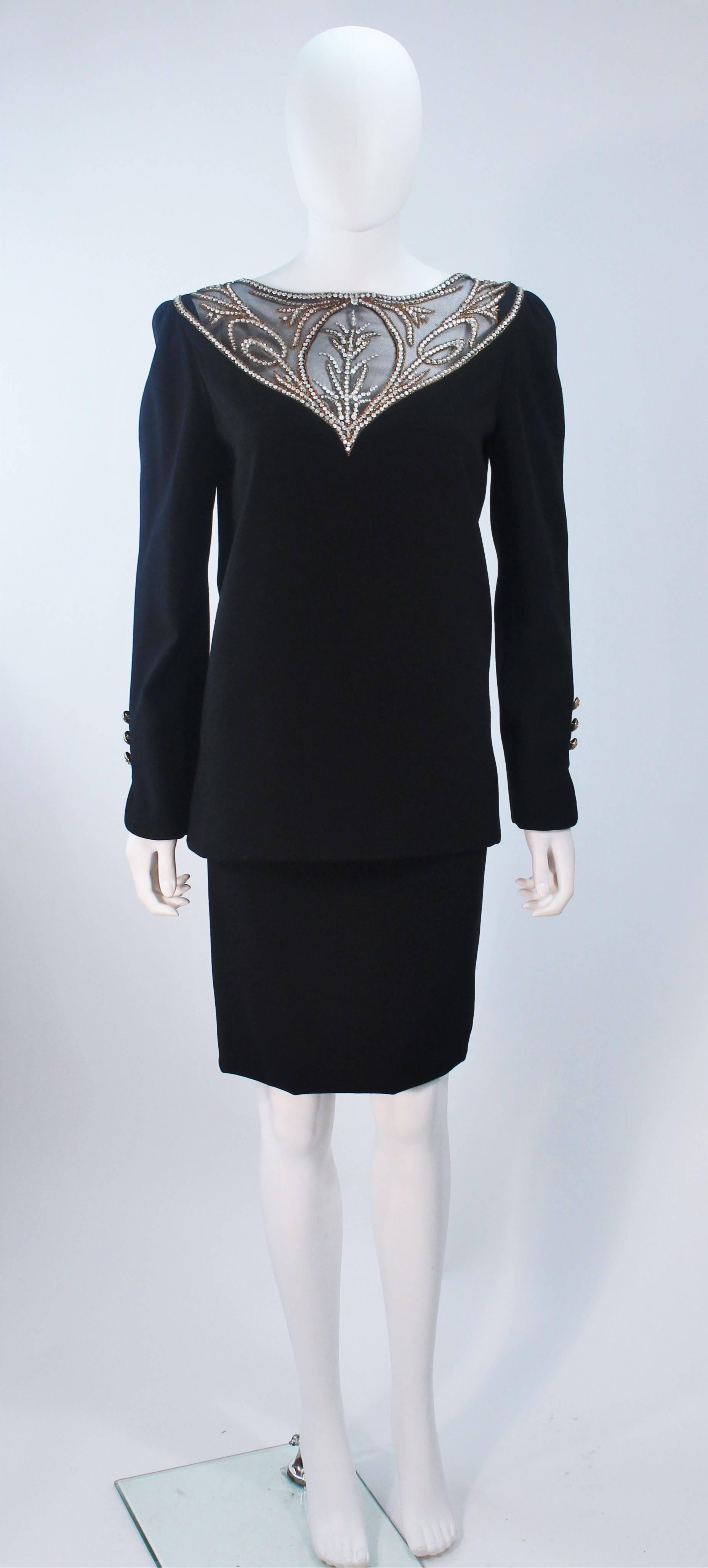  This Bob Mackie  ensemble is composed of a black wool with a sheer rhinestone accent at the upper neck and back. The blouse features a zipper closure. The classic pencil style skirt has a center back zipper closure. In excellent vintage condition.