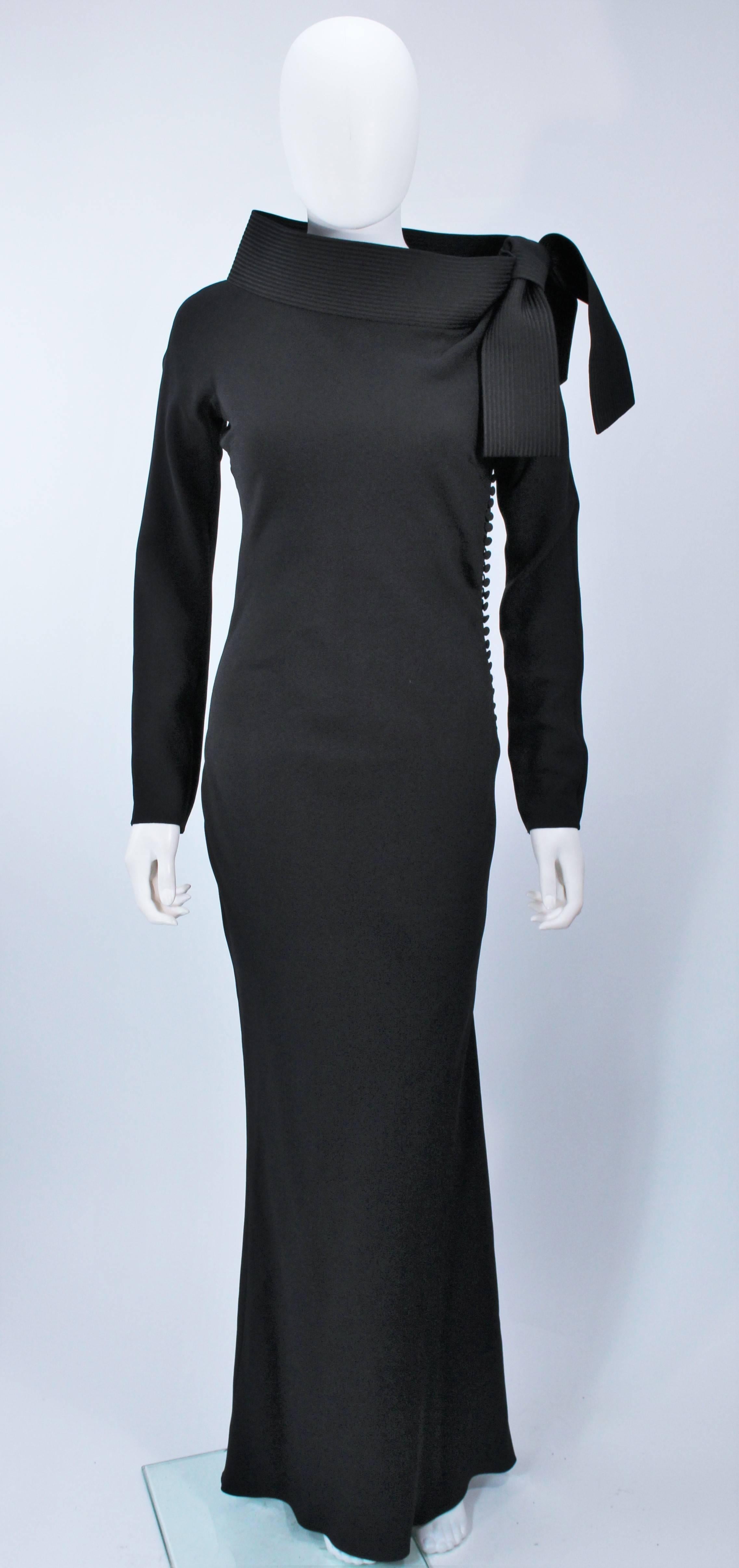 This Christian Dior gown is composed of a black crepe. Features an exaggerated collar with bow and top stitch detailing. There are side button closures. In excellent  condition. 

**Please cross-reference measurements for personal accuracy. 