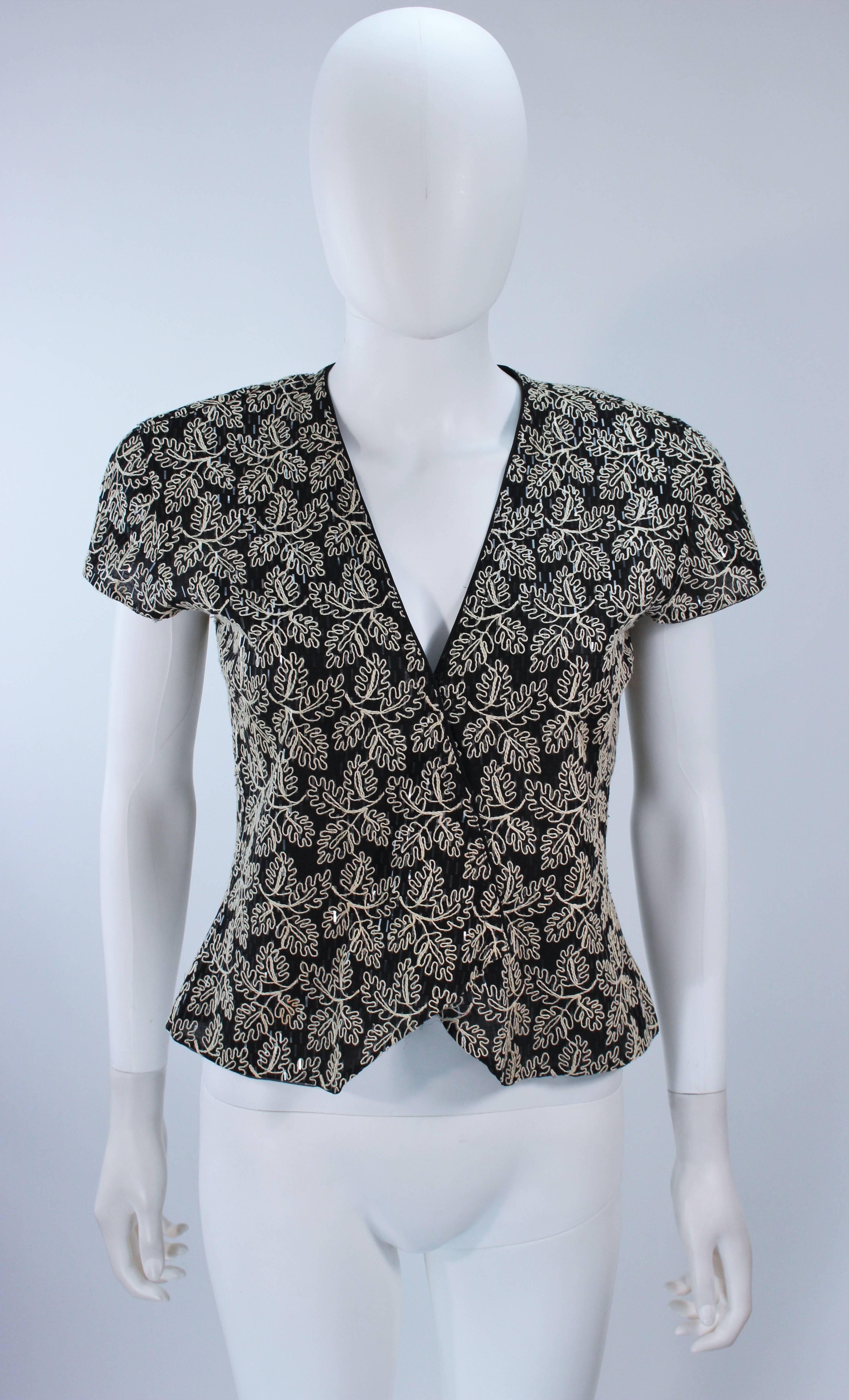  This Giorgio Armani  jacket is composed a black and white cotton with a floral motif and sequin applique. There are center front snap closures and shoulder pads. In excellent vintage condition. 

  **Please cross-reference measurements for