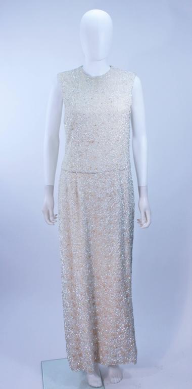 This dress is composed of a embellished silk with iridescent beading and sequins in a floral pattern. There is a center back zipper closure. In excellent vintage condition. 

  **Please cross-reference measurements for personal accuracy. Size in