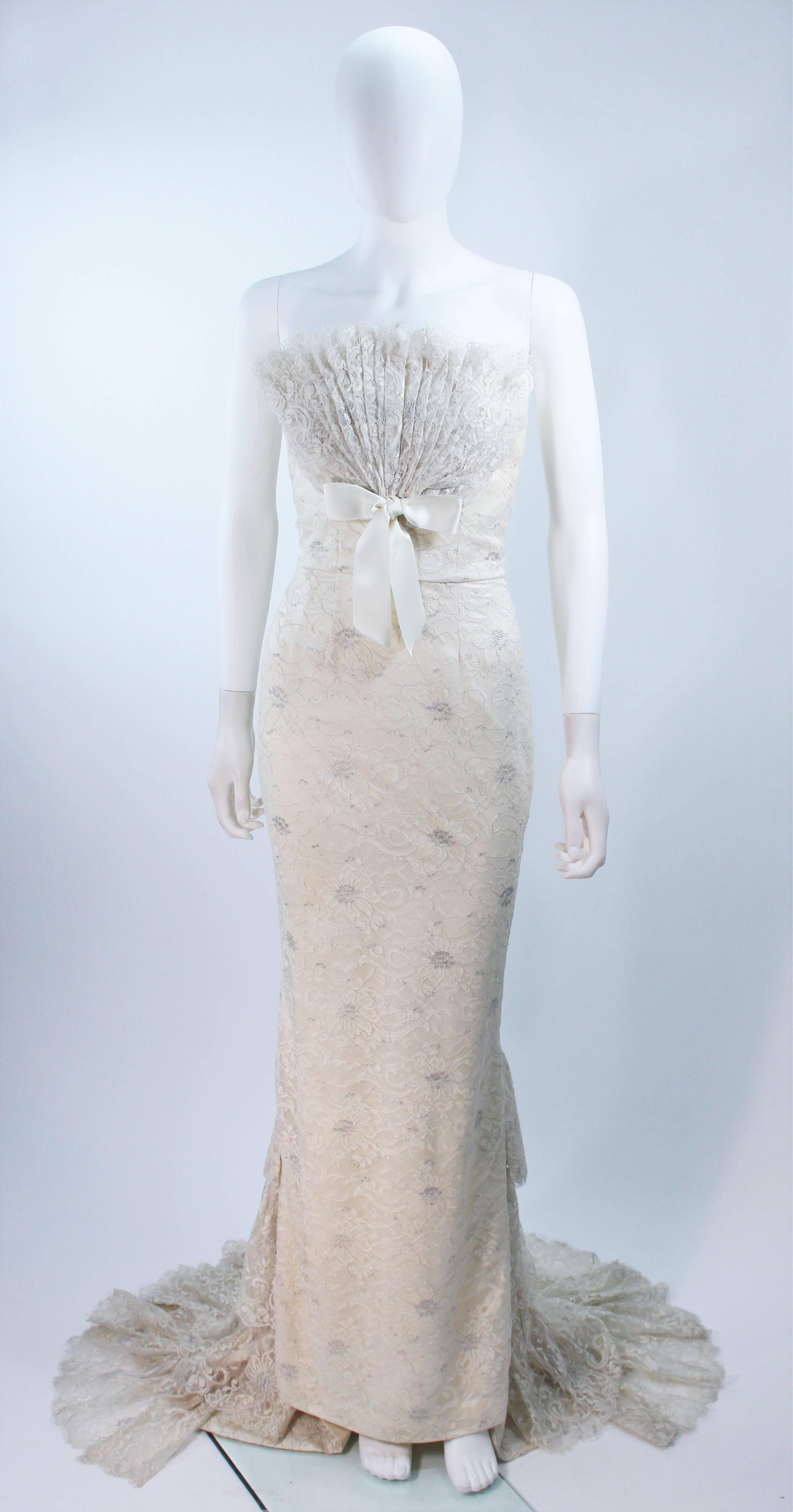 Cette robe Elizabeth Mason Couture présente un superbe drapé de dentelle avec une traîne et un buste en éventail. La base est entièrement désossée et la fermeture à glissière est cachée au centre du dos.

Il s'agit d'une commande sur mesure.
