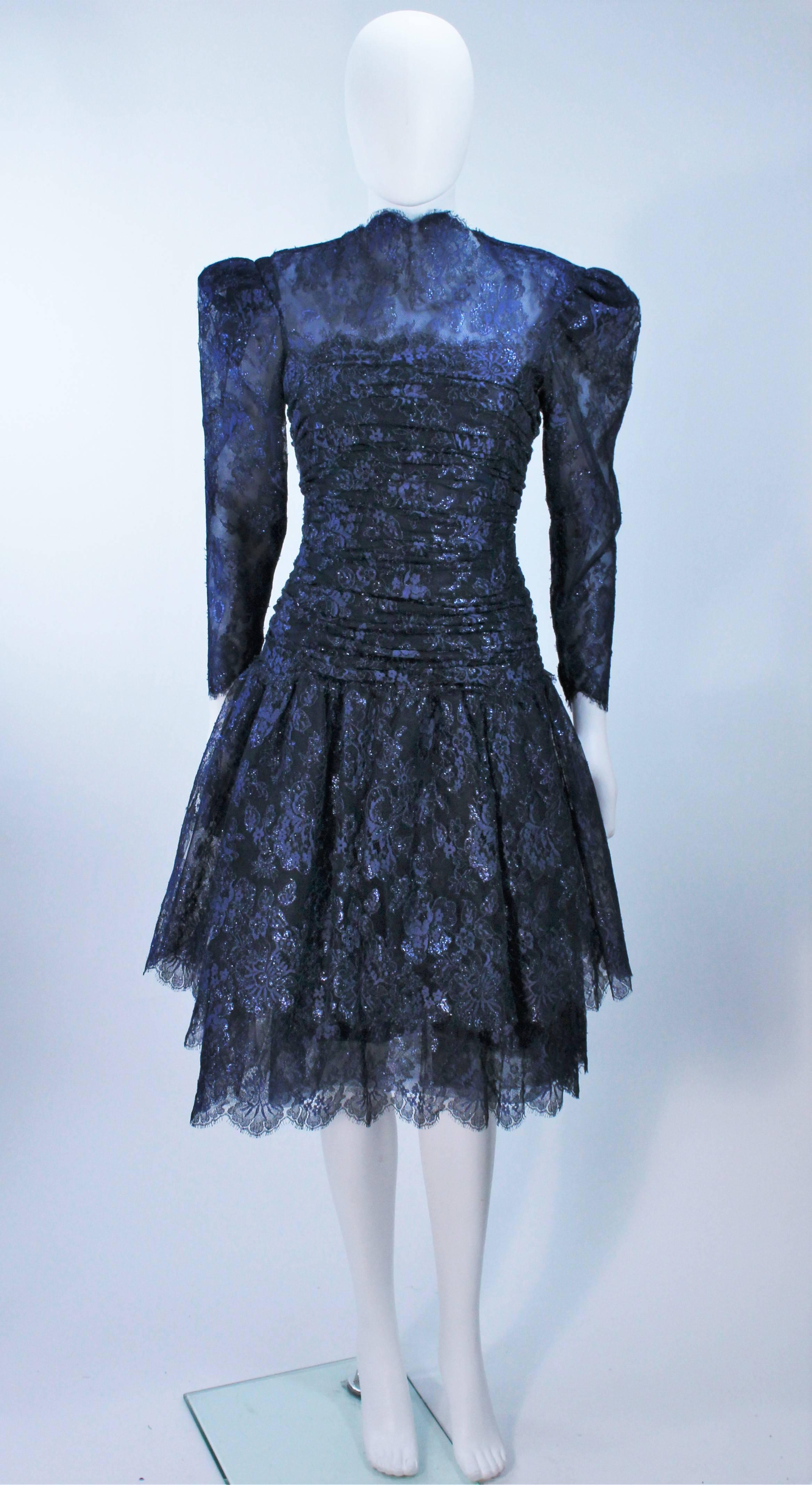  This Arnold Scaasi  cocktail dress is composed of a metallic navy lace with scalloped edges. There is a center back zipper closure, ruched waist details, and shoulder pad details. In excellent vintage condition. 

  **Please cross-reference