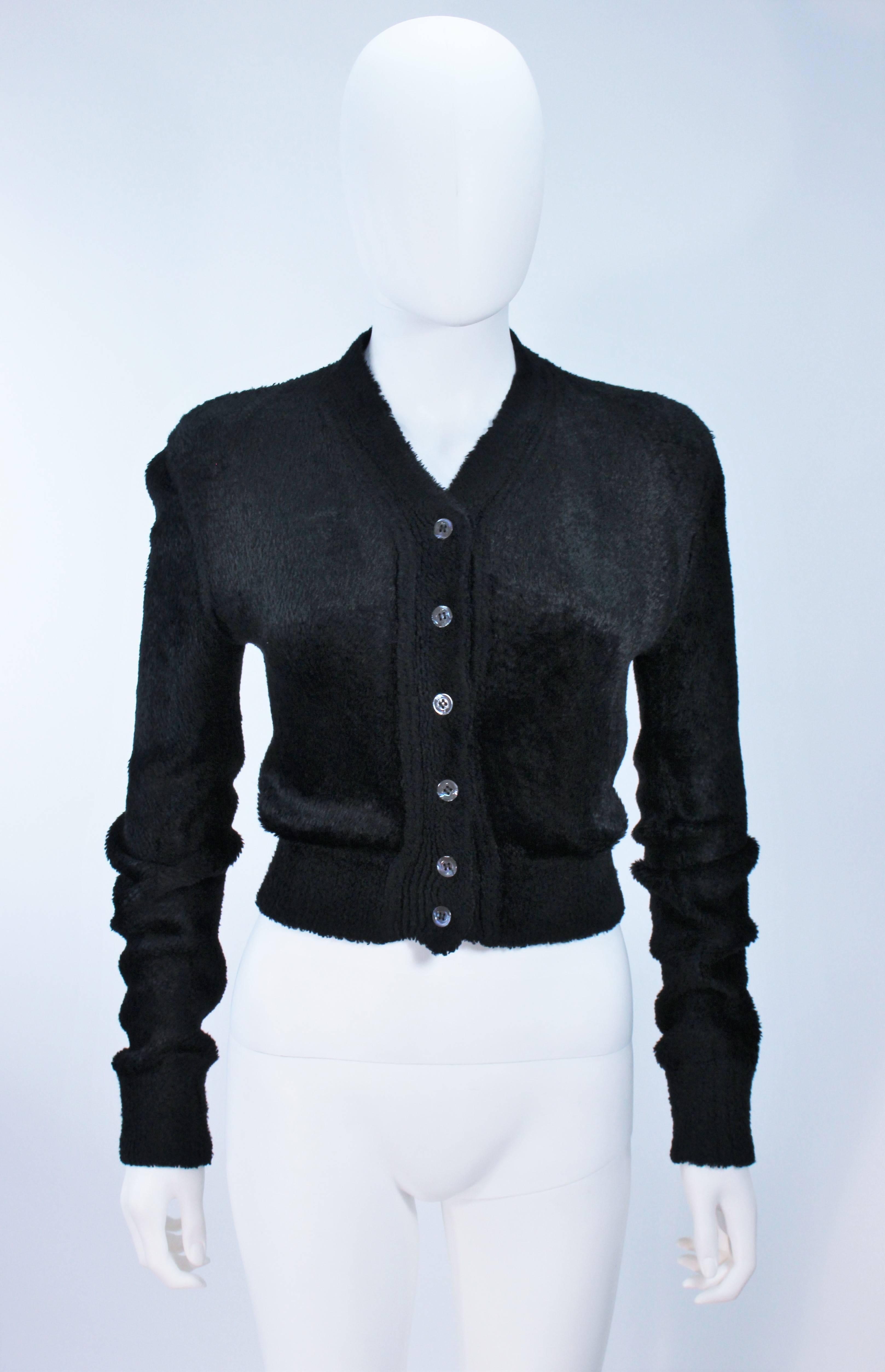  This Alaia  vintage sweater is composed of a very supple black fuzzy stretch material (viscose/rayon blend). There are center front button closures. In excellent vintage condition. 

  **Please cross-reference measurements for personal