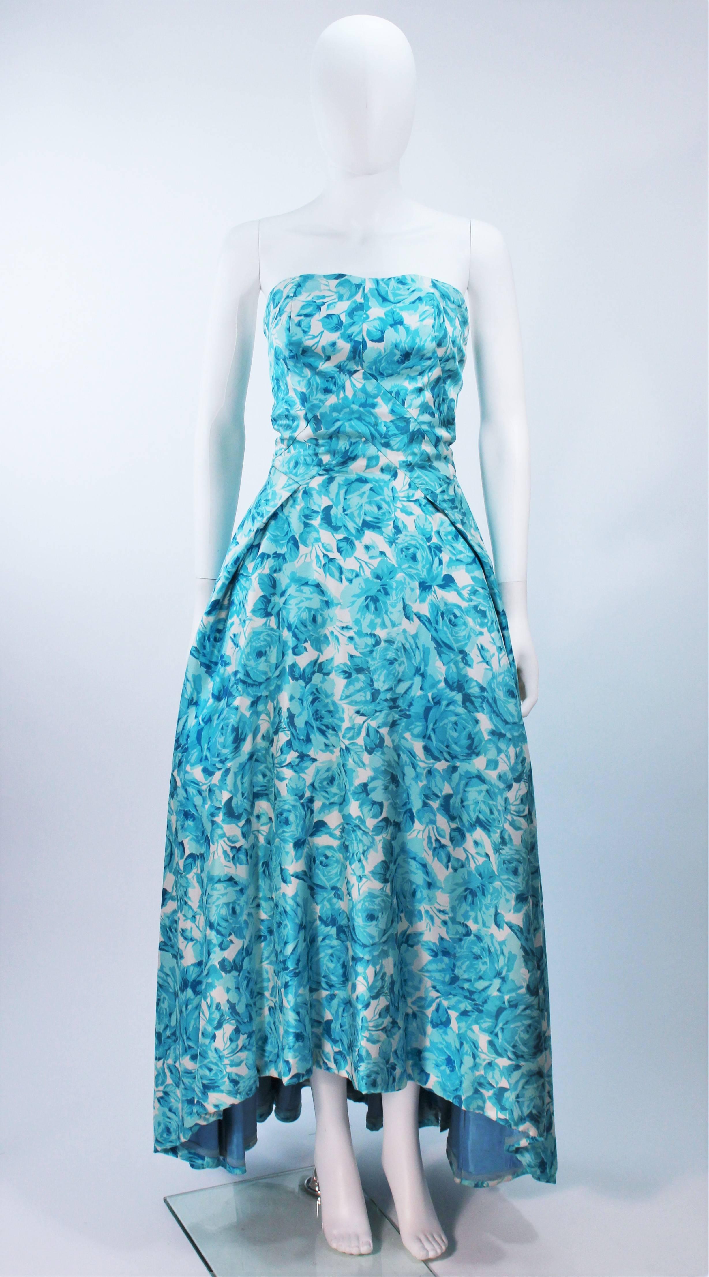  This gown is composed of an aqua and white fabric with a watercolor flower motif. Features a high - low skirt. There is a center back zipper closure. (photographed with crinoline, not included). Beautiful design, in excellent vintage condition.