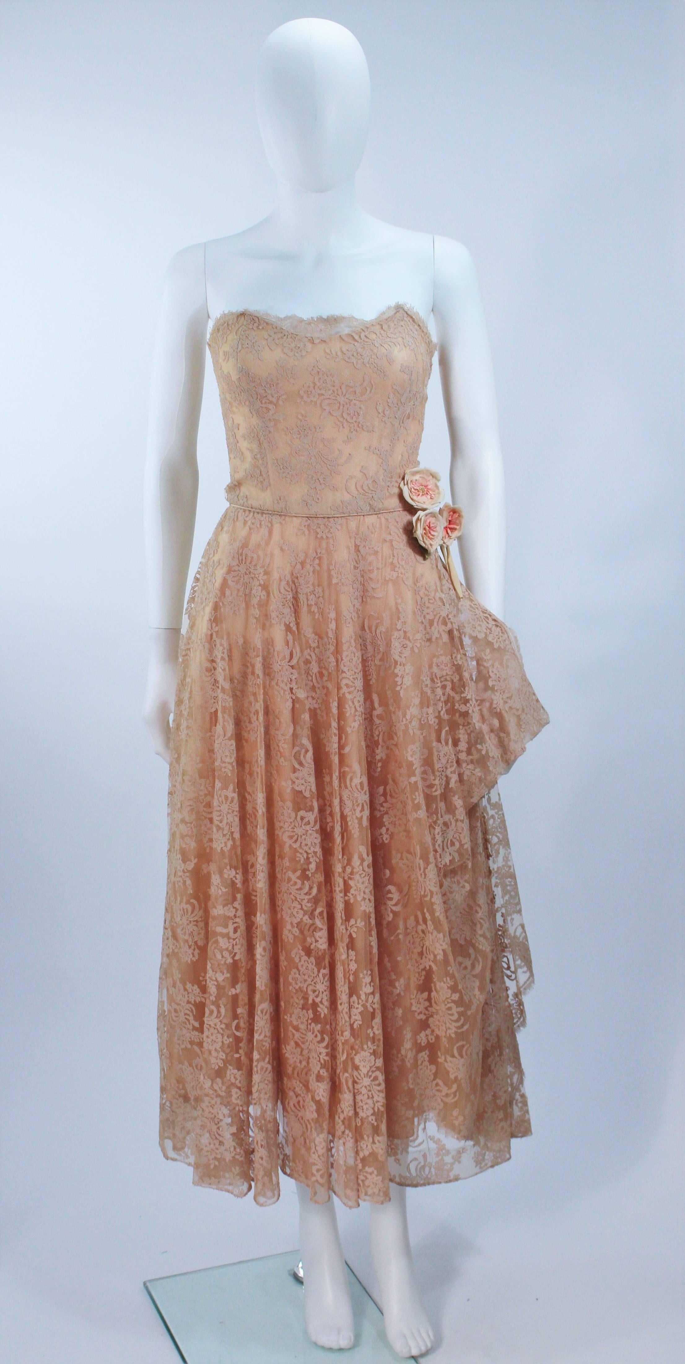  This Ceil Chapman  cocktail dress is composed of a nude lace. Features a draped strapless style with side floral applique. There is a center back zipper closure. In excellent vintage condition. 

  **Please cross-reference measurements for