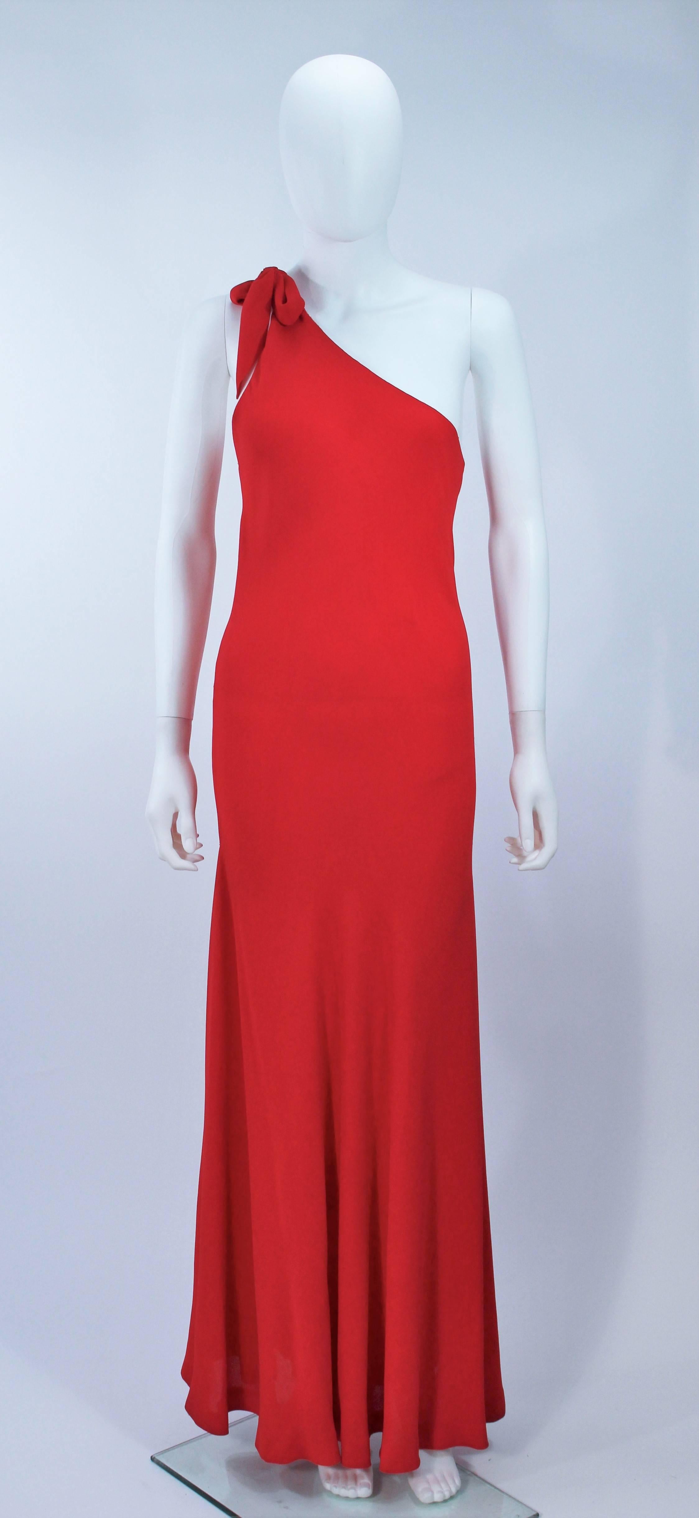  This Halston  ensemble features a bias cut asymmetrical chiffon gown with a jersey cape, in a beautiful hue of red. The gown is a pull on style. Sold 'As Is' good vintage condition, the dress has a few pulls and discoloration by the hem. 

 