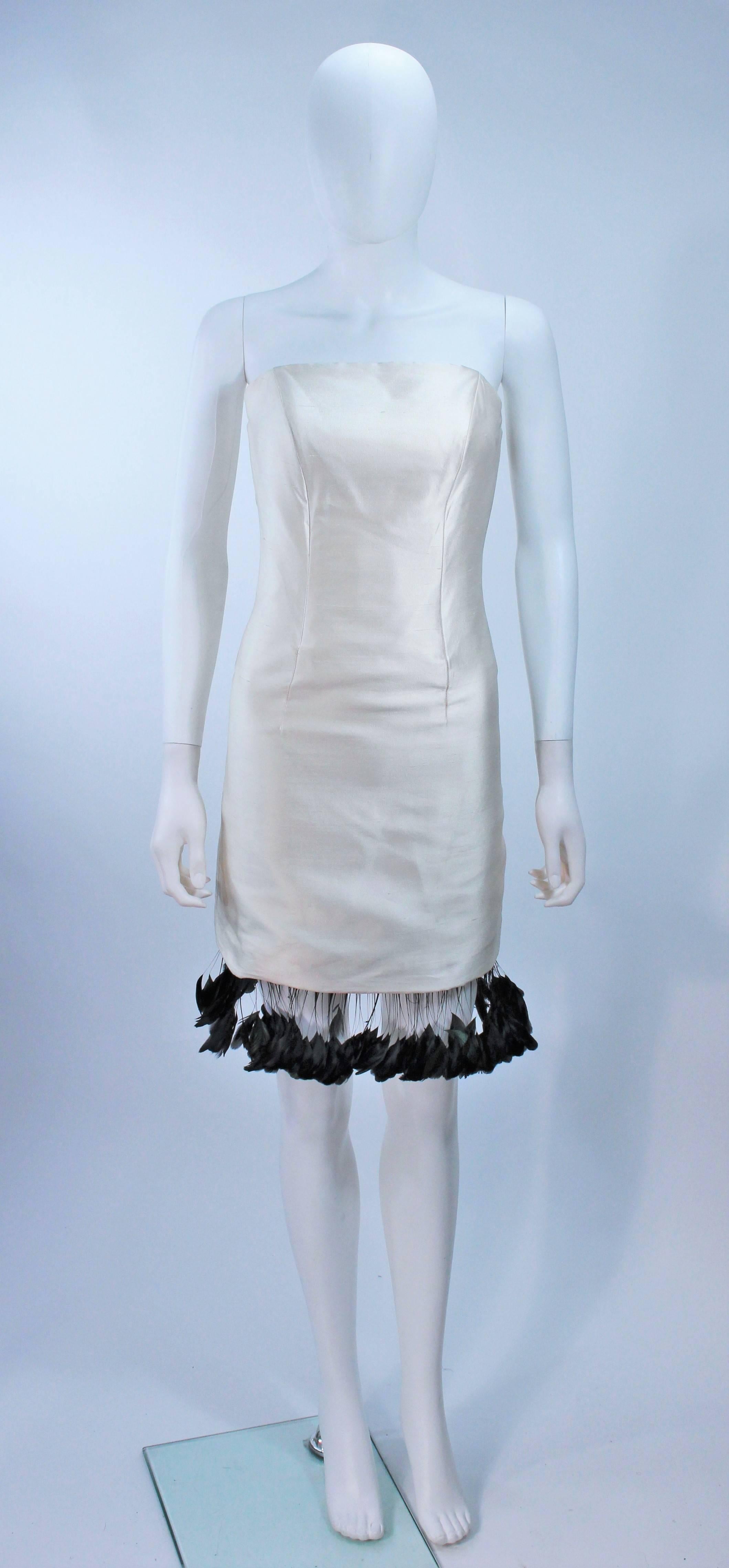  This Cantu & Castillo cocktail dress is composed of a raw white silk with a black iridescent feather trim. There is a center back zipper closure. In great vintage condition. 

  **Please cross-reference measurements for personal accuracy. Size in