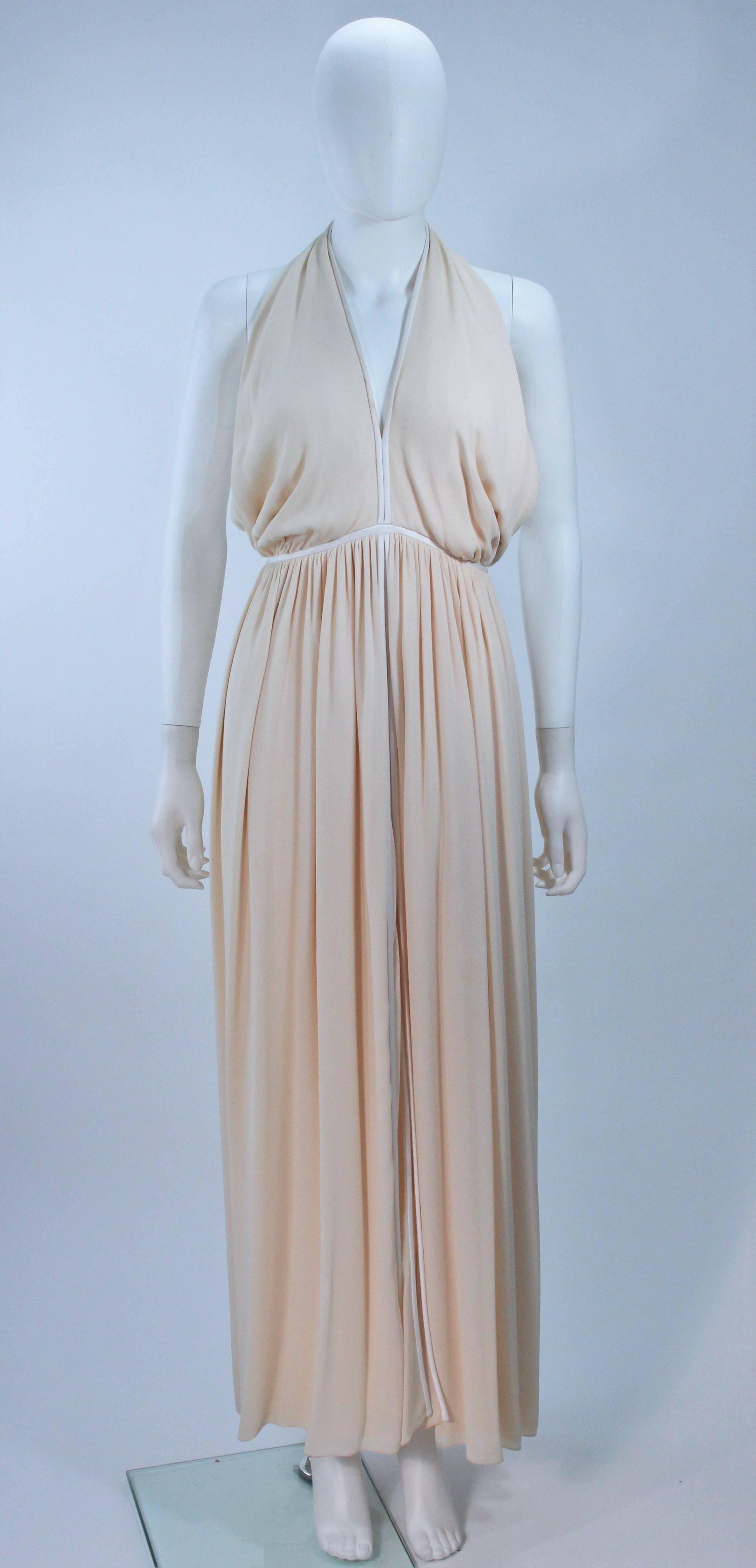  This Galanos  gown is composed of cream and ivory silk. Features a center front slit. There is a center back zipper closure. In excellent vintage condition. 

  **Please cross-reference measurements for personal accuracy. Size in description box