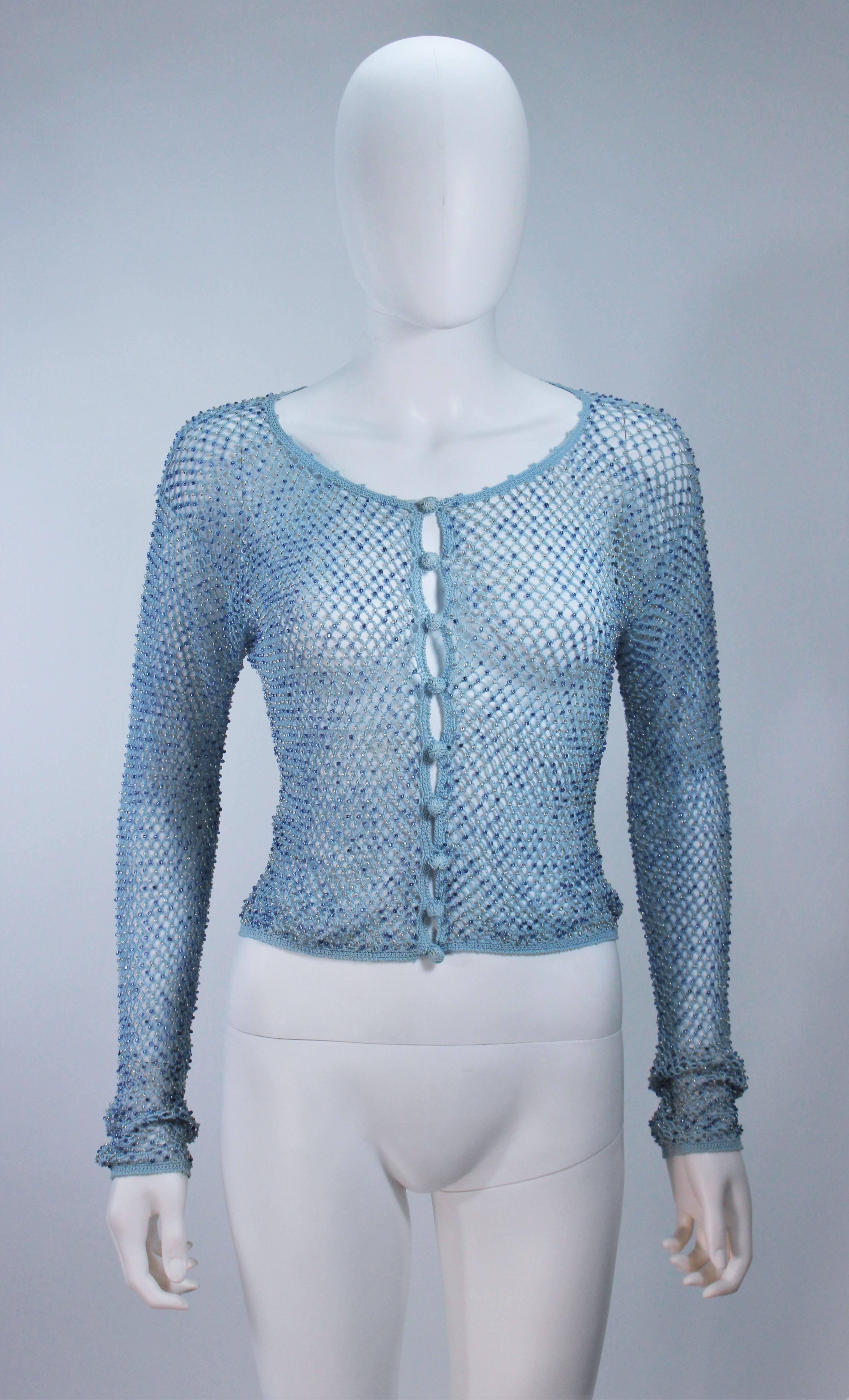 This Moschino  sweater is composed of a sky blue knit and features beaded applique. There are center front button closures. In great condition, with original tags. 

  **Please cross-reference measurements for personal accuracy. Size in