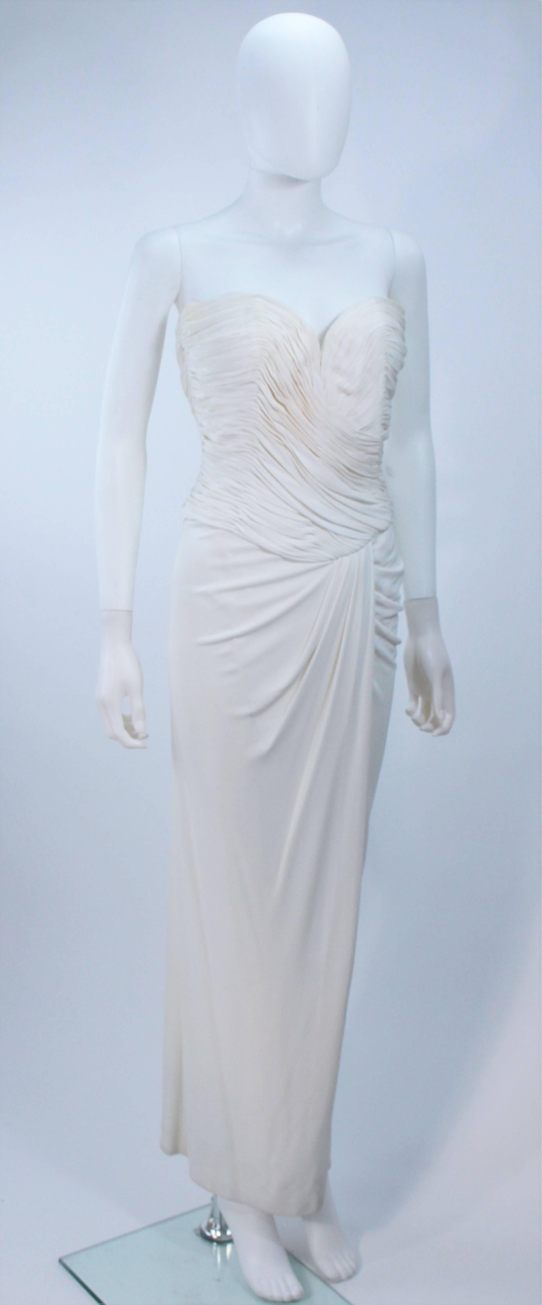  This Vicky Tiel  gown is composed of a draped jersey. Features a ruched bodice, front slit, and sweetheart neckline. There is a center back zipper closure with interior boning. In great vintage condition. 

  **Please cross-reference measurements