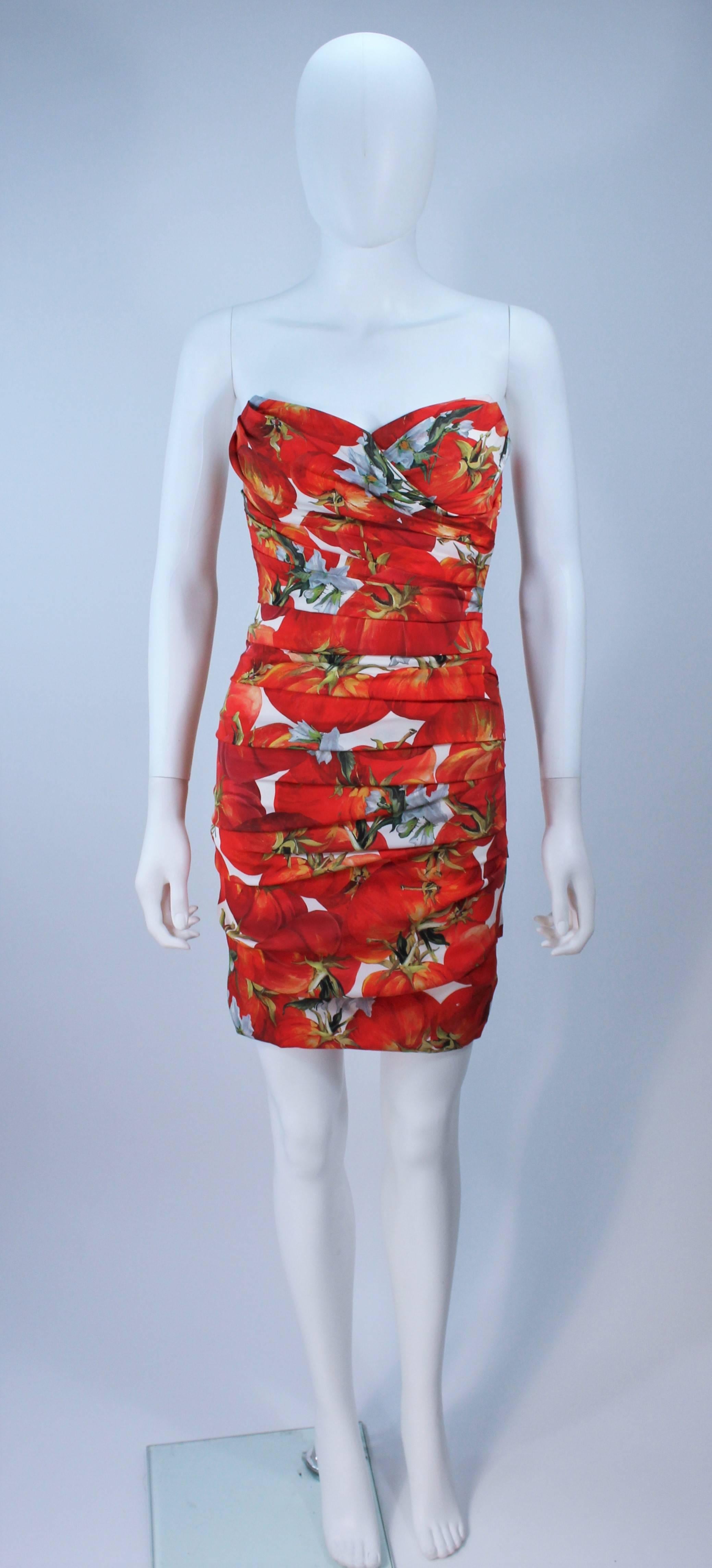  This Dolce and Gabbana  dress is composed of a printed stretch silk (with a tomato design). Features ruched details throughout and a center back zipper closure. There is interior boning. In excellent condition. 

  **Please cross-reference