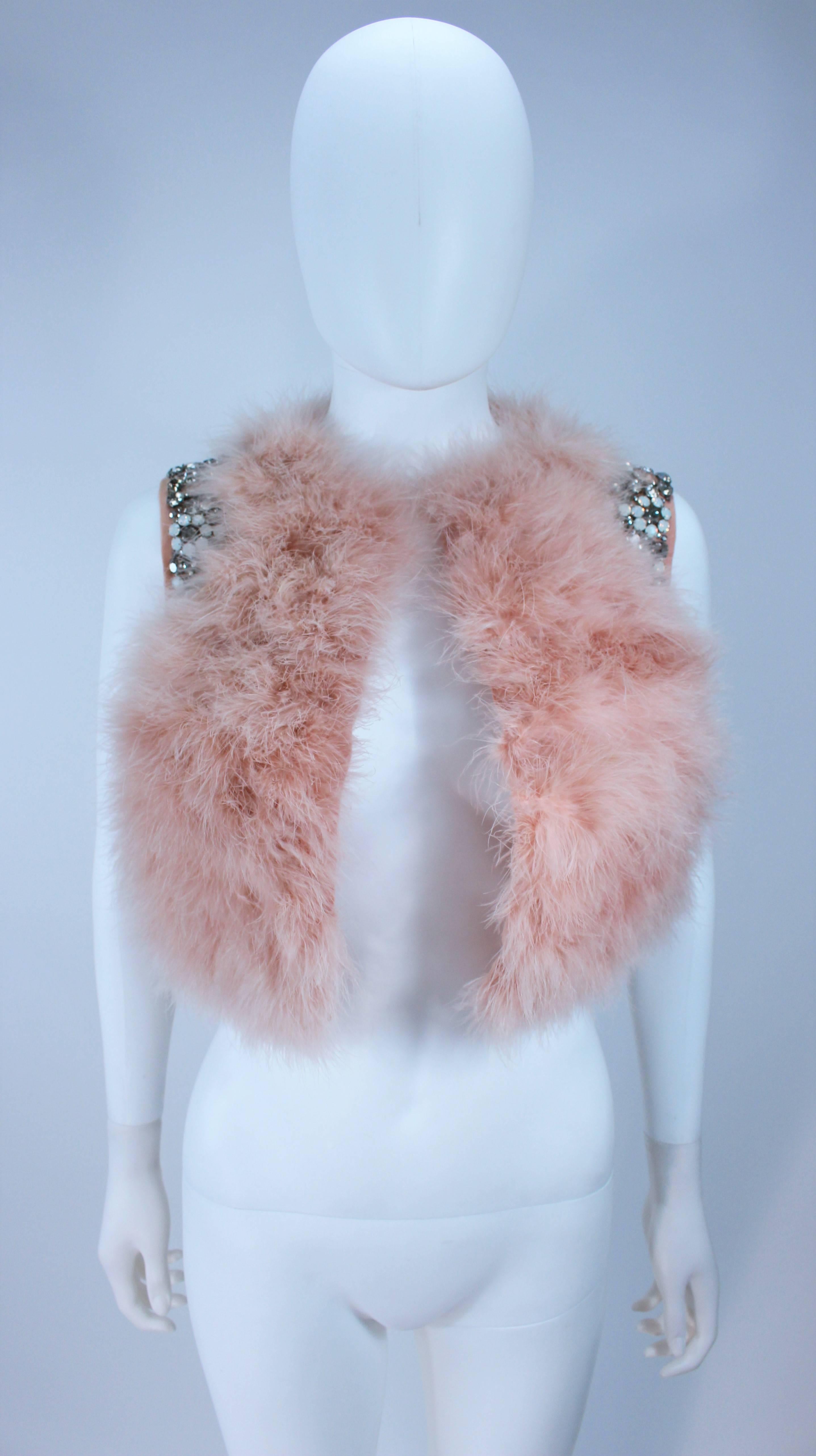  This Givenchy  jacket is composed of a soft mauve pink marabou and features rhinestone jewel accents at the shoulders. The base is composed of silk and features a silk organza interior. In excellent condition. 

  **Please cross-reference