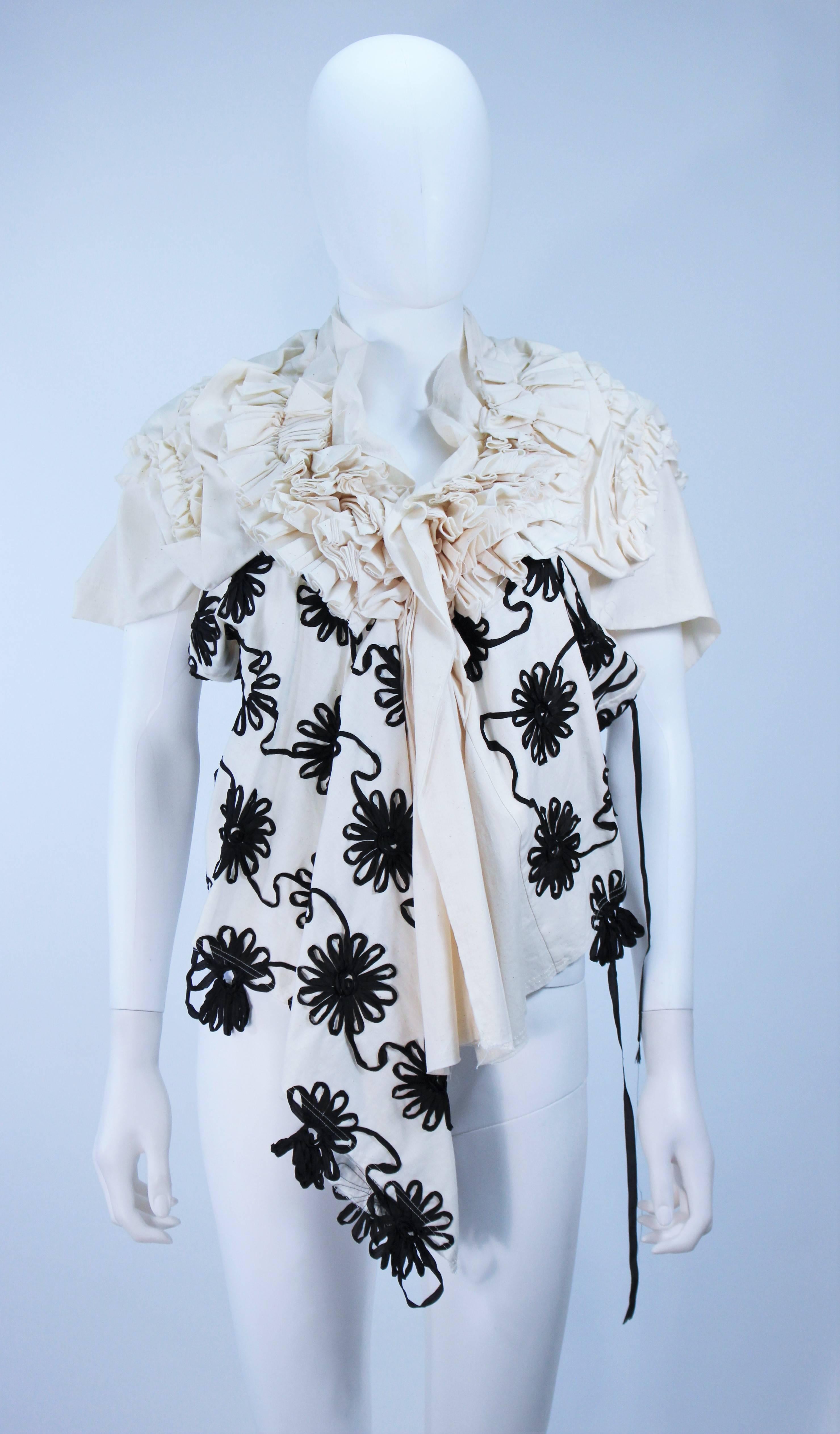  This Comme Des Garcons  top is composed of a natural hue cotton with a floral applique. Features dramatic sleeves with gathers throughout. In like new condition. 

  **Please cross-reference measurements for personal accuracy. 

Measures