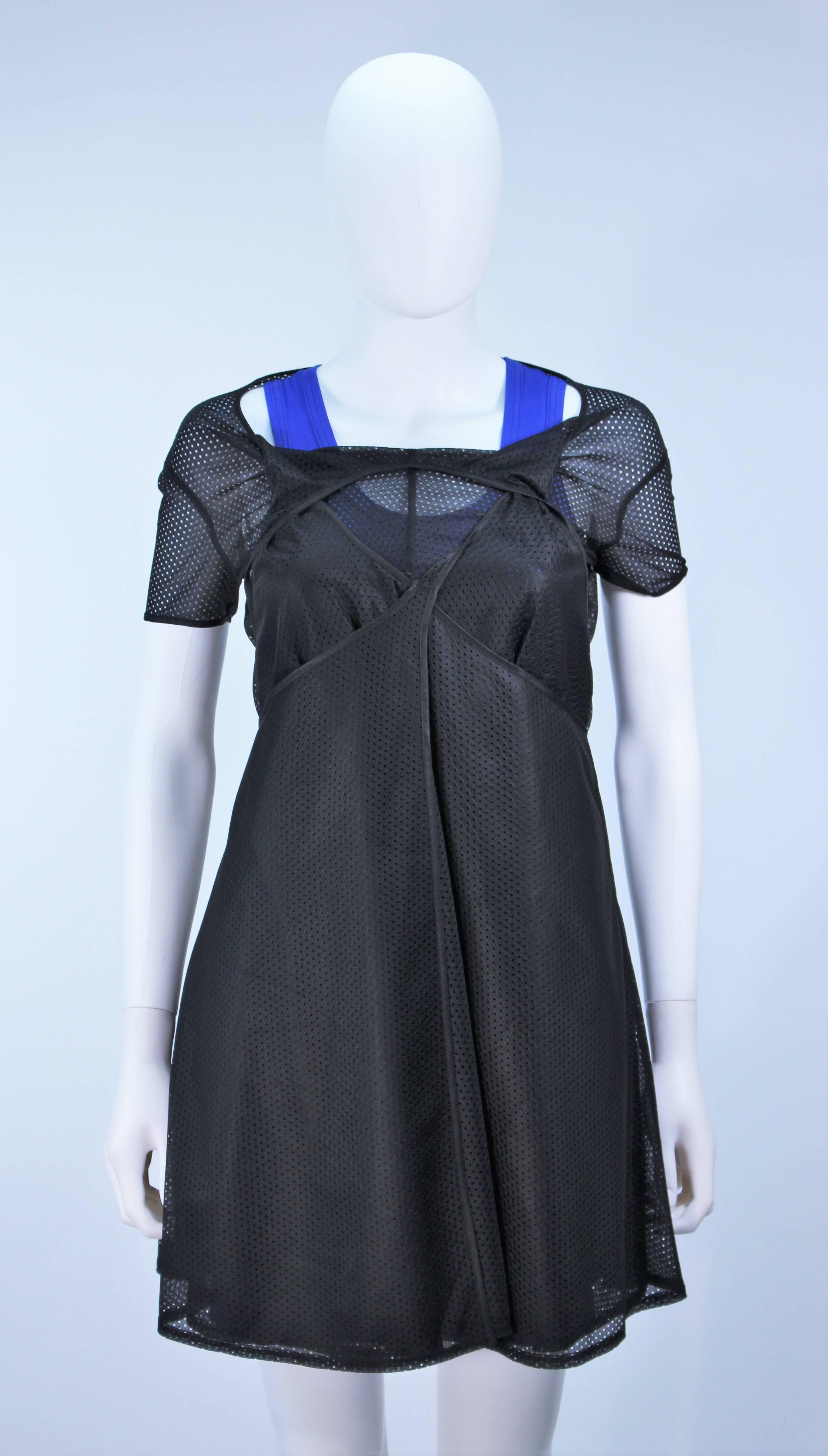  This Comme Des Garcons  ensemble is composed of an exterior draped mesh dress and an interior blue jersey dress. The exterior dress features a flared skirt and draped neck, the blue interior dress has a racer back style with stretch. In like new