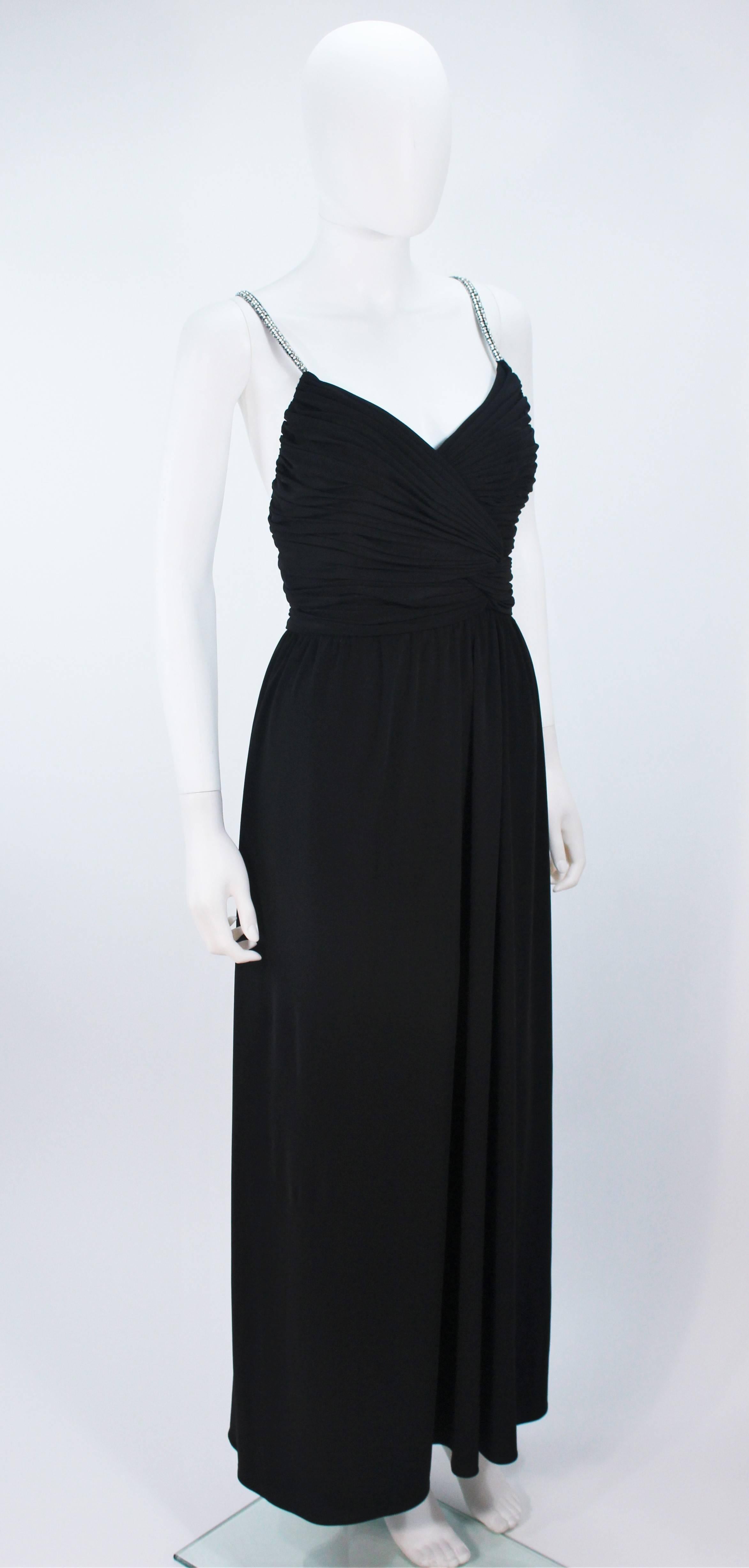  This Victoria Royal gown is composed of a black draped jersey with rhinestone straps. Features a draped design with center back zipper and criss-cross straps. Lined. In great vintage condition.

  **Please cross-reference measurements for